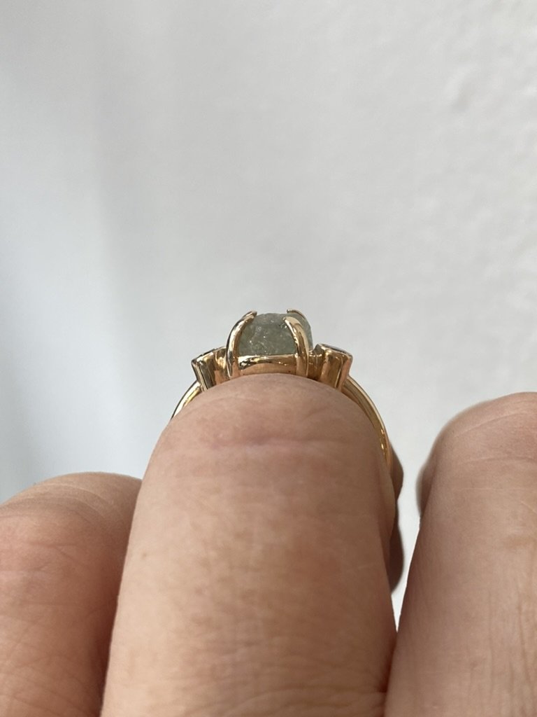 round Montana minty blue green claw set engagement ring with side bezel set champagne diamonds 14k yellow gold through finger view on hand Kim Drosdick Jewellery Toronto