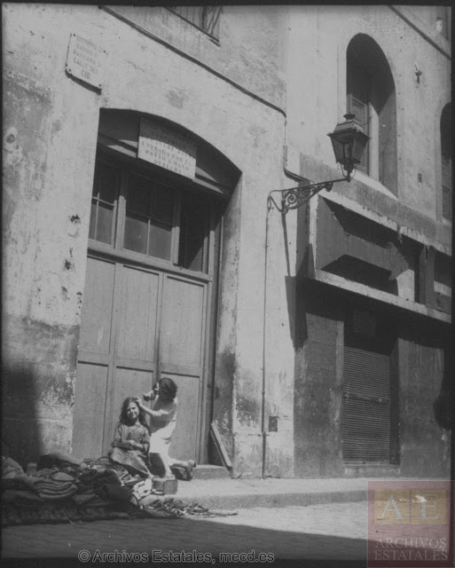 Dos niñas frente a la puerta de la Casa de Dormir. A su lado, en el número anterior de la calle Cid, la fachada de La Criolla cerrada con una verja