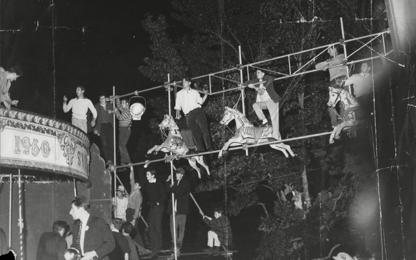 Los fans comienzan a subirse a la estructura de un pequeño parque de atracciones justo al lado del escenario