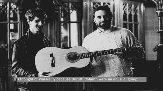 Reilly, de manos de Julio Anguita, recibe la guitarra en un fotograma de Una guitarra para Durruti