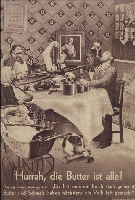 Fotomontaje de John Heartfield para la revista AIZ. El texto dice «¡Hurra, se acabó la mantequilla», en referencia a un discurso de Joseph Goebbels pronunciado el 17 de enero de 1936 en el que el ministro de propaganda nazi afirmó «Uno no puede disparar con mantequilla, pero sí con cañones».