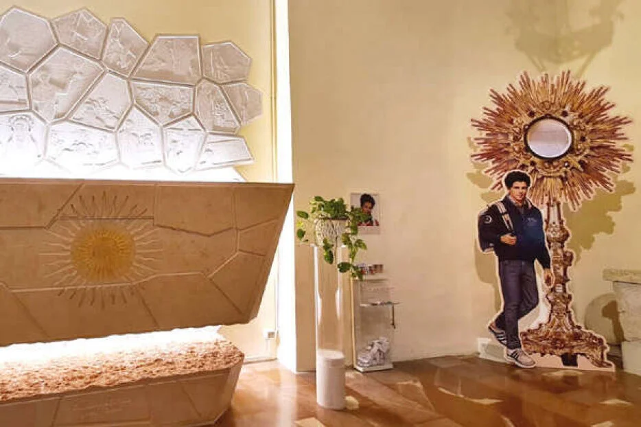 Capilla donde reposa el cuerpo de Carlo Acutis, con sendos recortables del muchacho y de un sagrario.