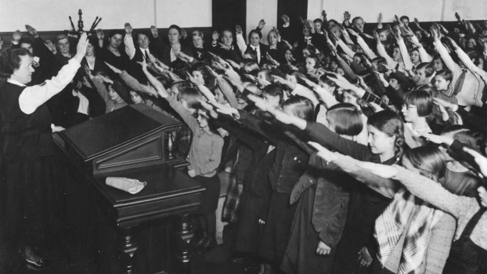 Una clase entera haciendo el polémico saludo (circa 1920)