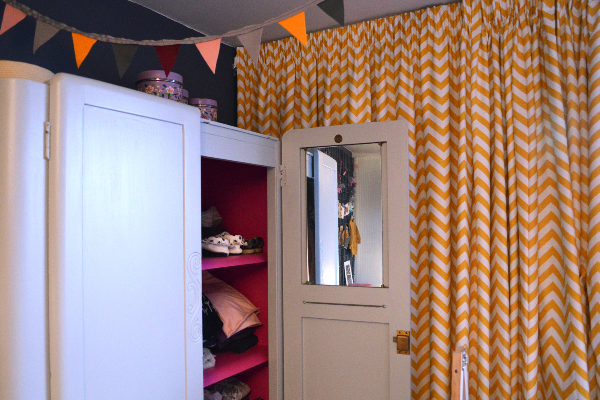 The hot pink charity-shop-find wardrobe interior is a cool concession to girliness