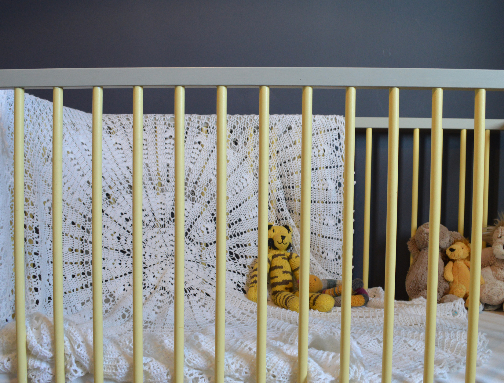 The Ikea cot is painted in Farrow &amp; Ball's Day Room Yellow and Manor House Gray