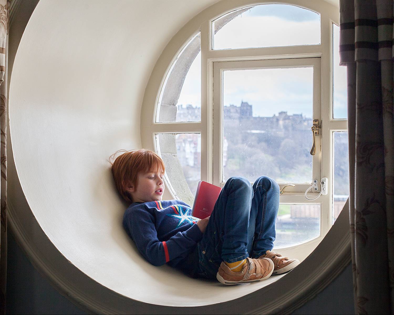 So that's what's through the round window:&nbsp;Oscar and his hotel 'passport', with Edinburgh Castle in the background