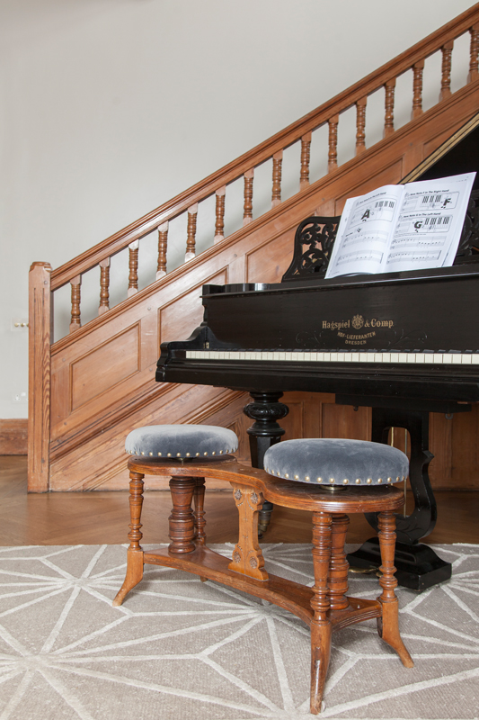 Grand piano with vintage double stool reupholstered in grey velvet/Photo: Susie Lowe