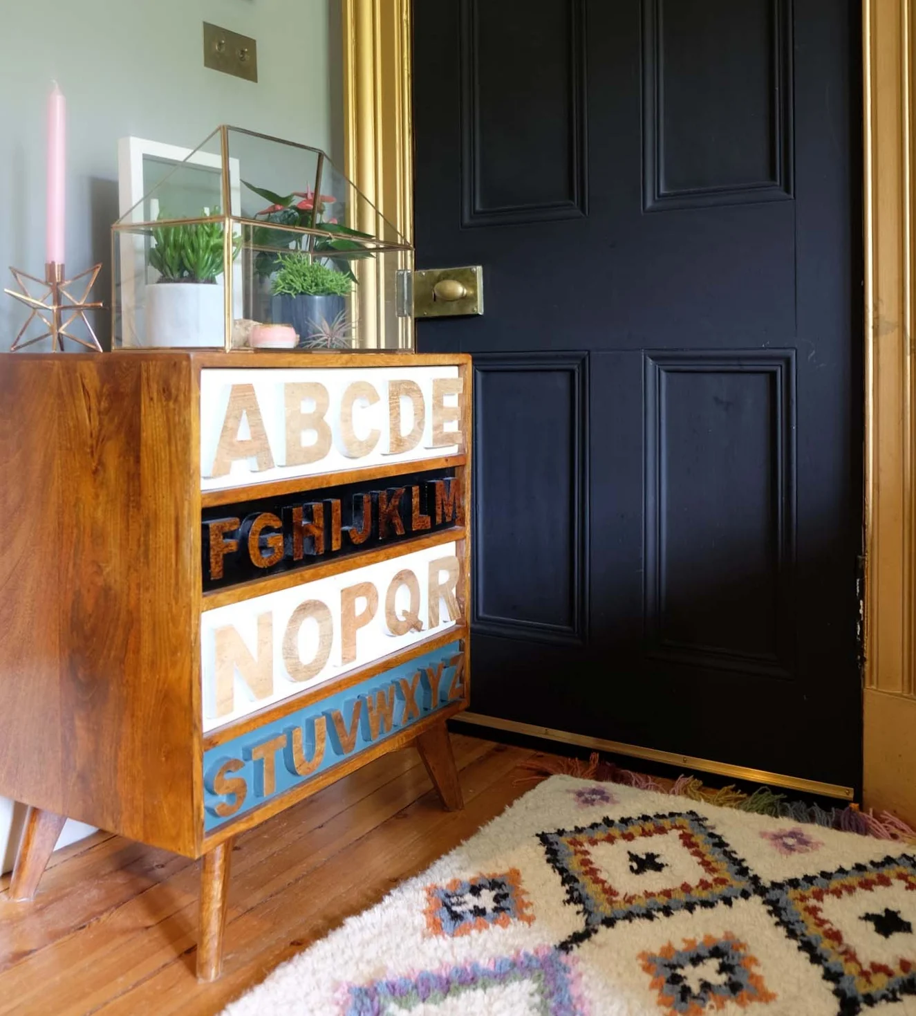Mini glass and brass greenhouse ; Copper Estello candlestick ; Ourika wool rug ; White and black Sevan marble pots , all La Redoute