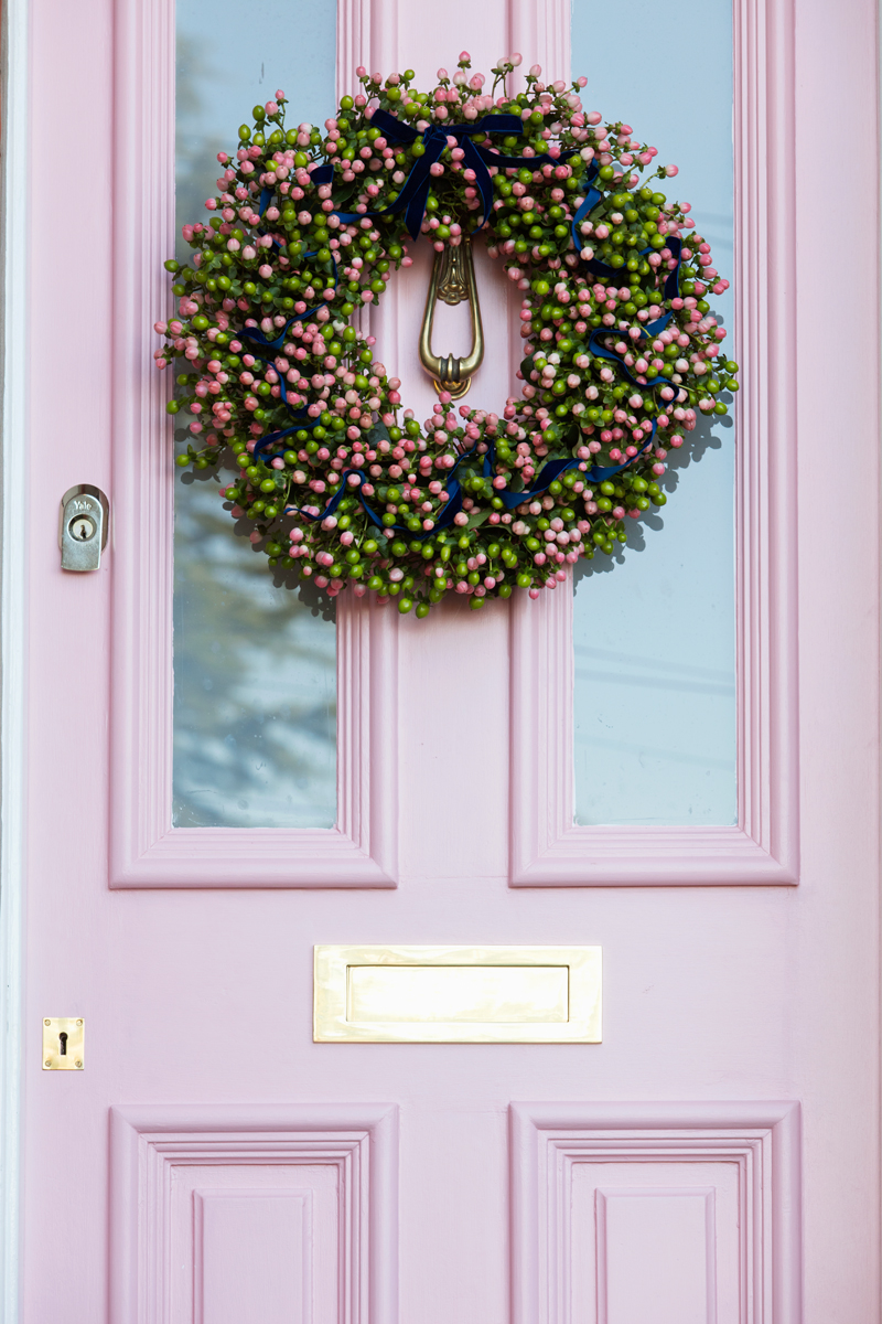 Pink hypericum berries wreath on pink front door