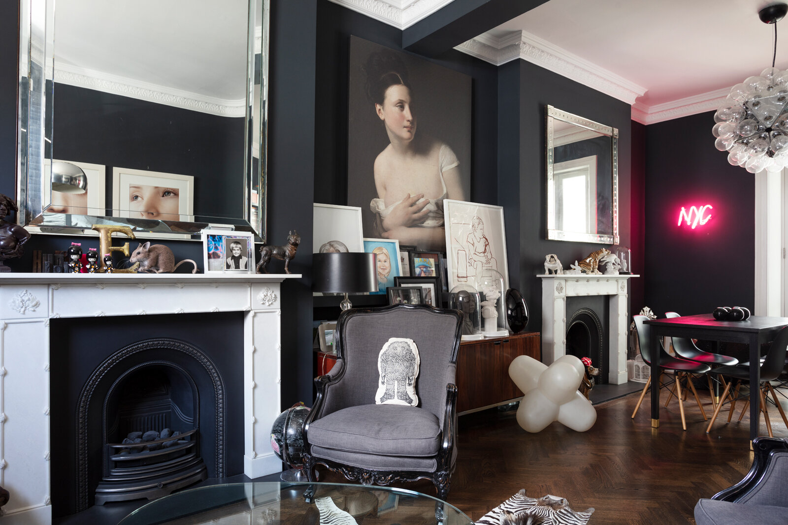 Black sitting room painted in Farrow & Ball's Railings with pink neon sign