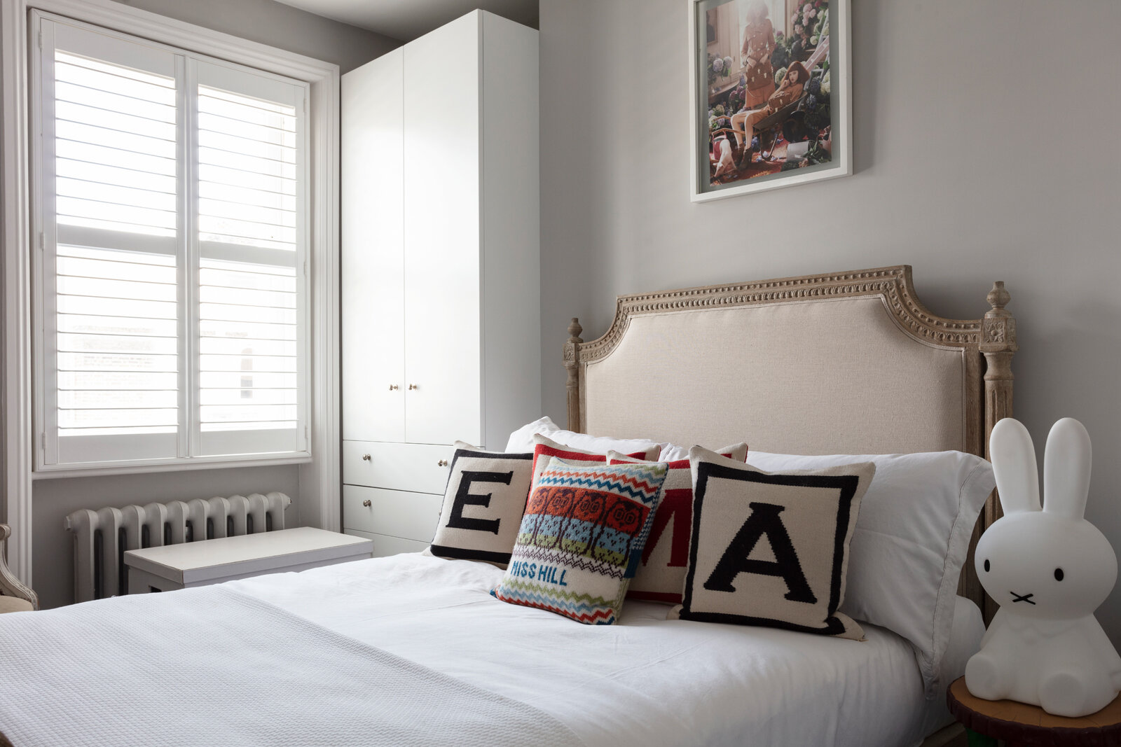 White spare room with alphabet cushions and fancy headboard
