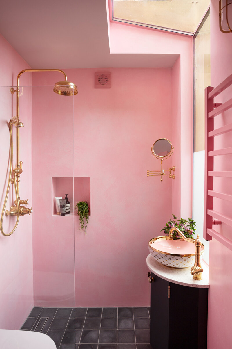 Pink polished plaster bathroom with brass shower and taps and gold sink