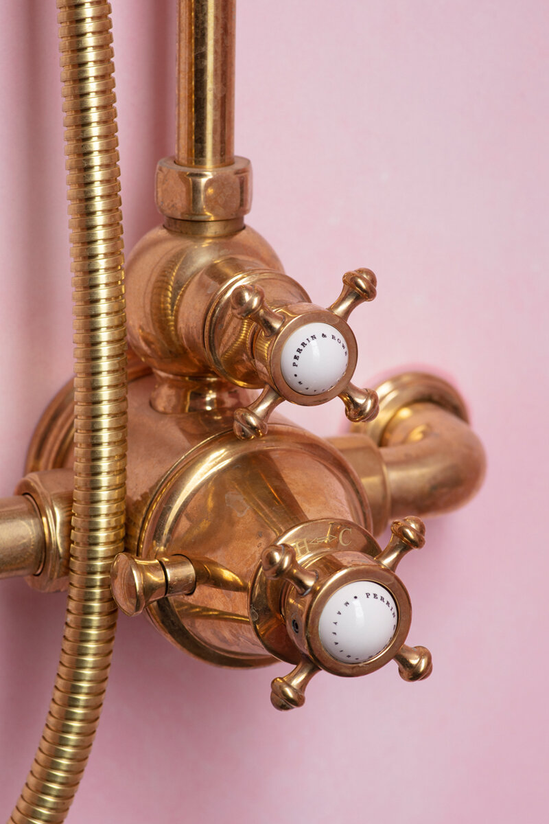 Shower mixer close up. The knob on the left is the safety catch