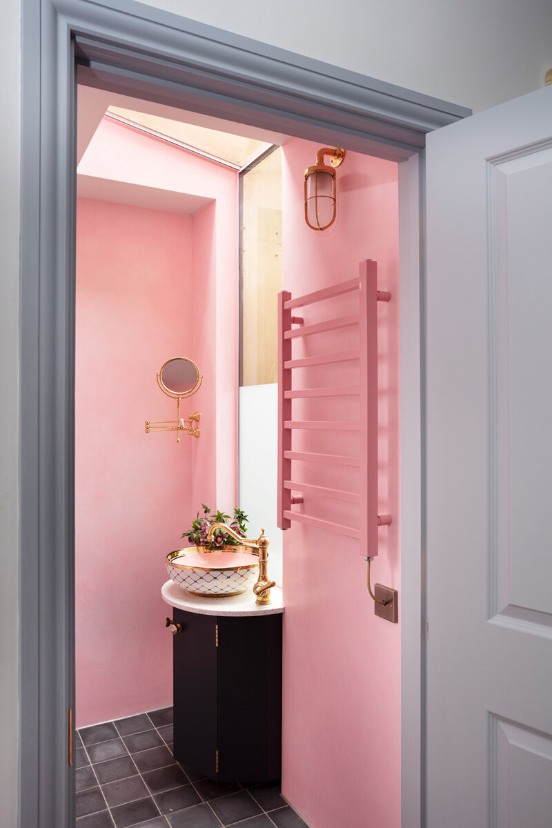 Beautiful brass Ship’s Well light from Original BTC above a powder-coated pink radiator