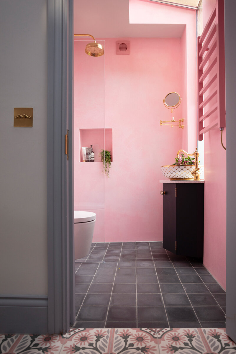 Pink bathroom with brass taps and shower and gold and pink sink