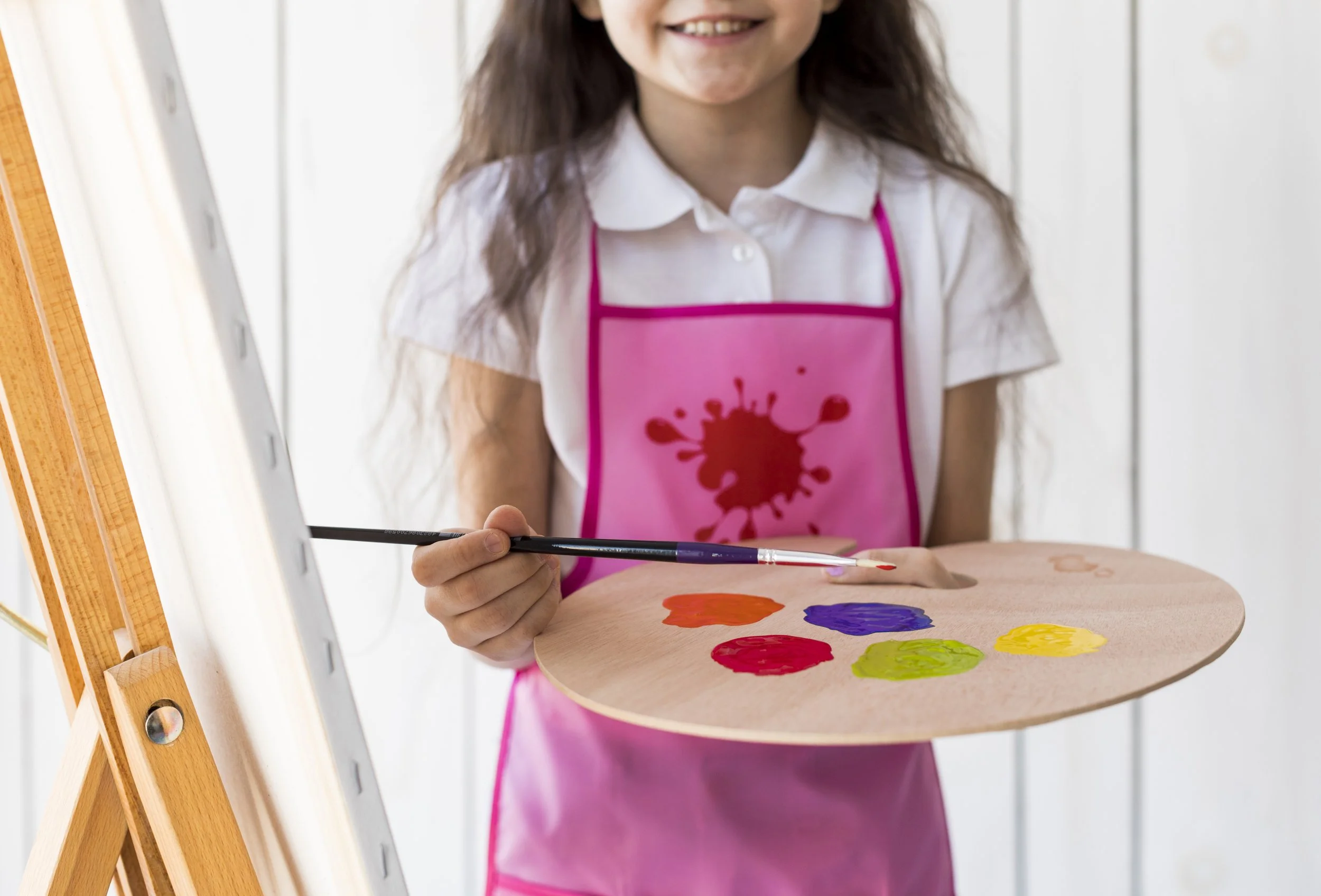 mid-section-smiling-girl-holding-paintbrush-palette.jpg