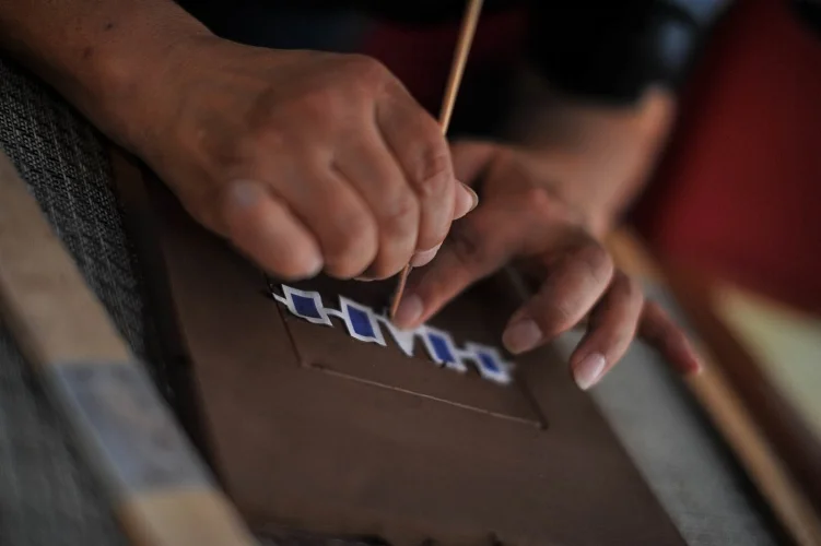 Transferring an image onto the wet clay. Photo credit: Andrew Alexander 