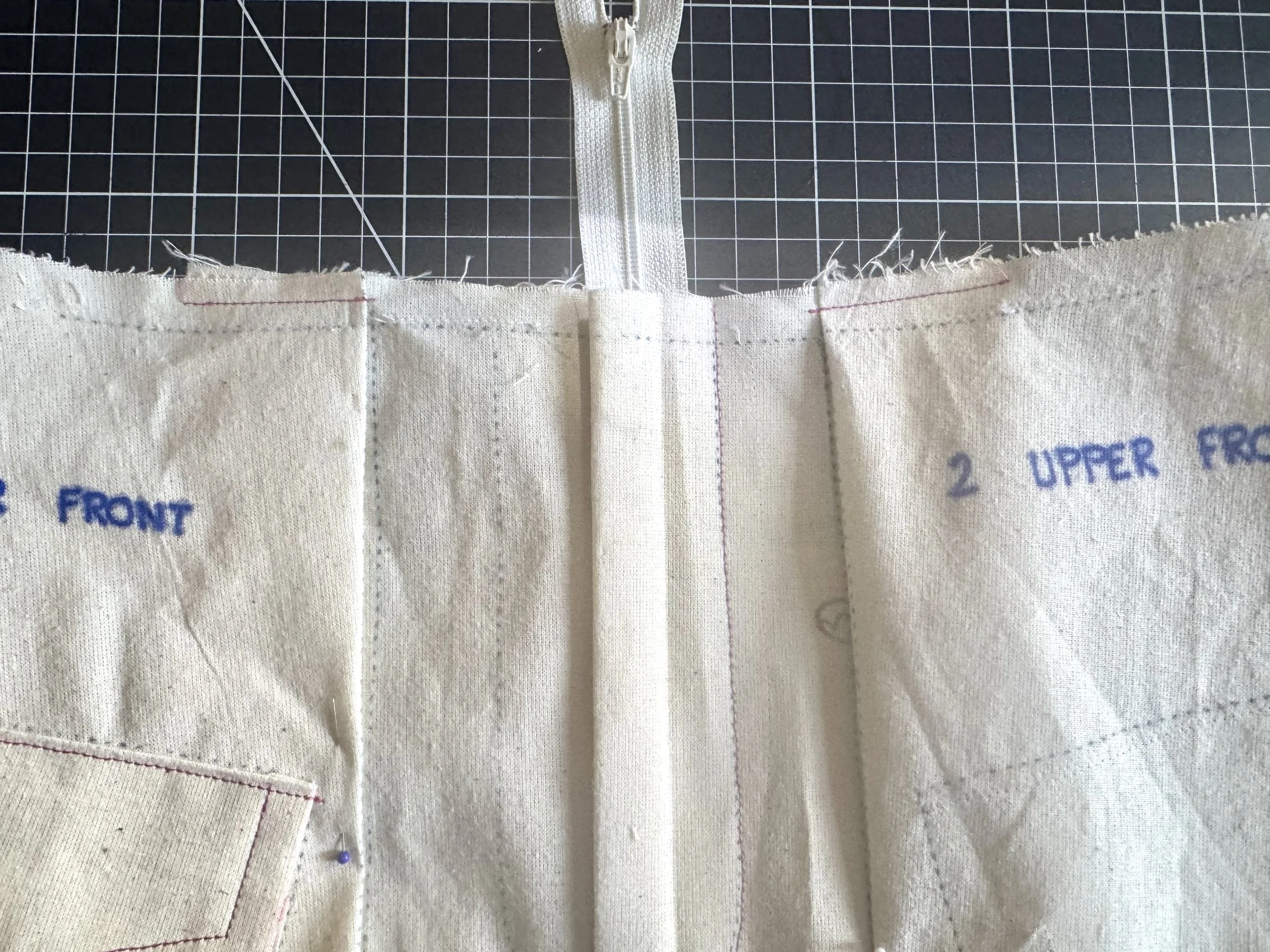  When the pockets are attached, fold your two upper pleats in towards the center.  Stitch close to the edge to hold. 
