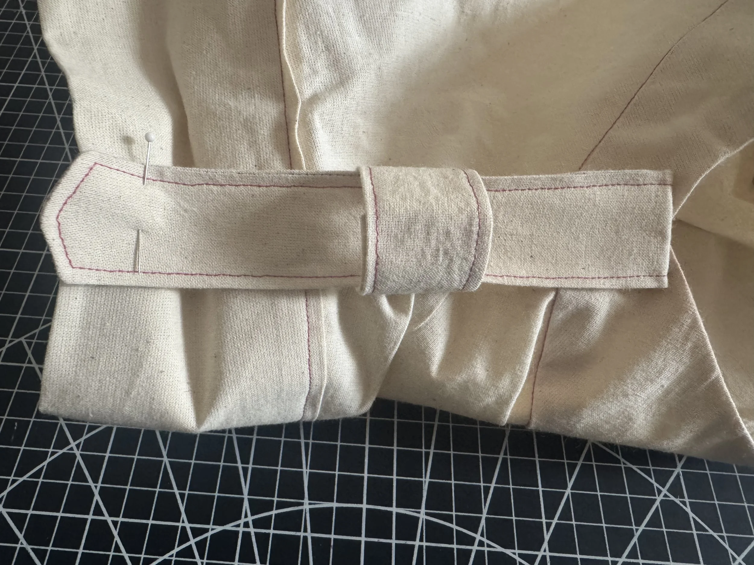  Slide the loop on and pin the strap point close to the sleeve edge. 