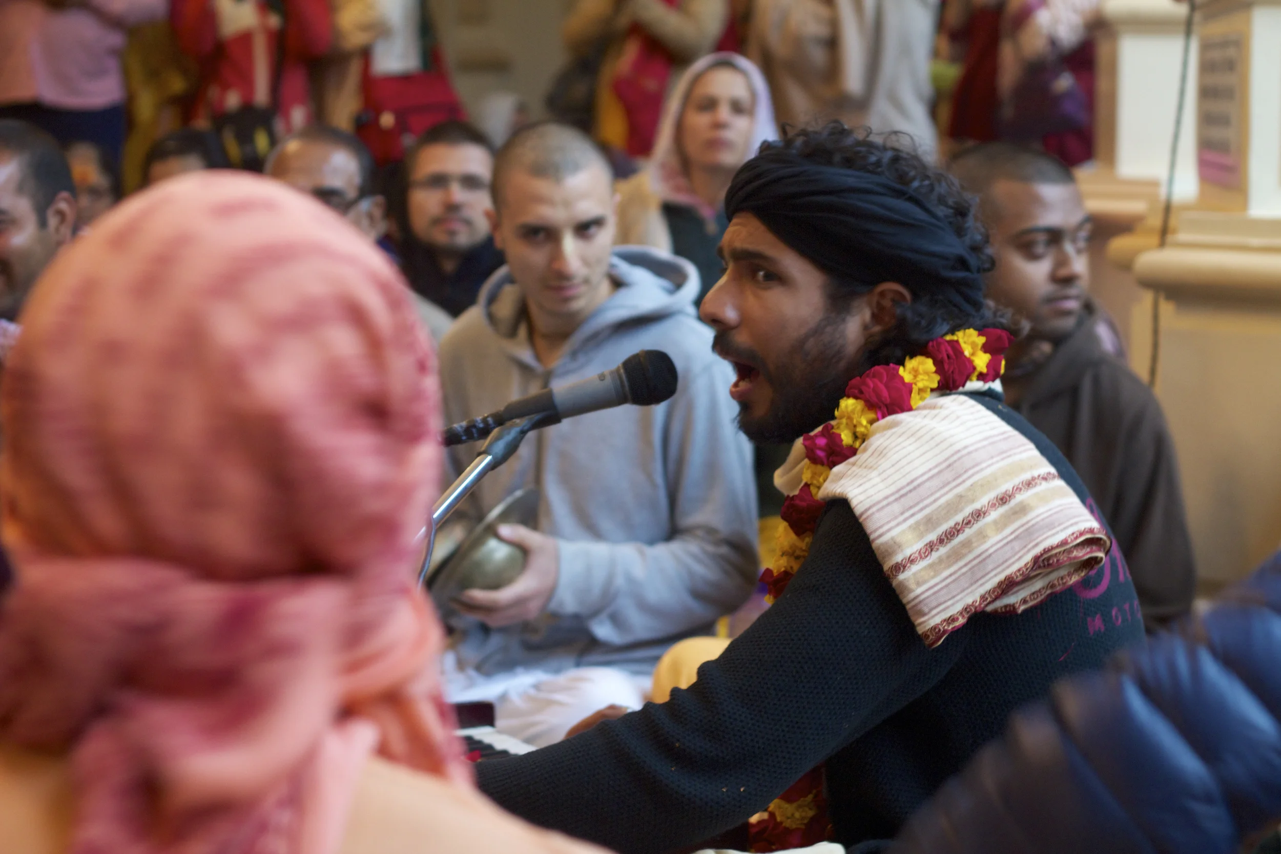A musician leads a Hare Krishna chant among devotees in the ISKCON mandir in Vrindavan, India.