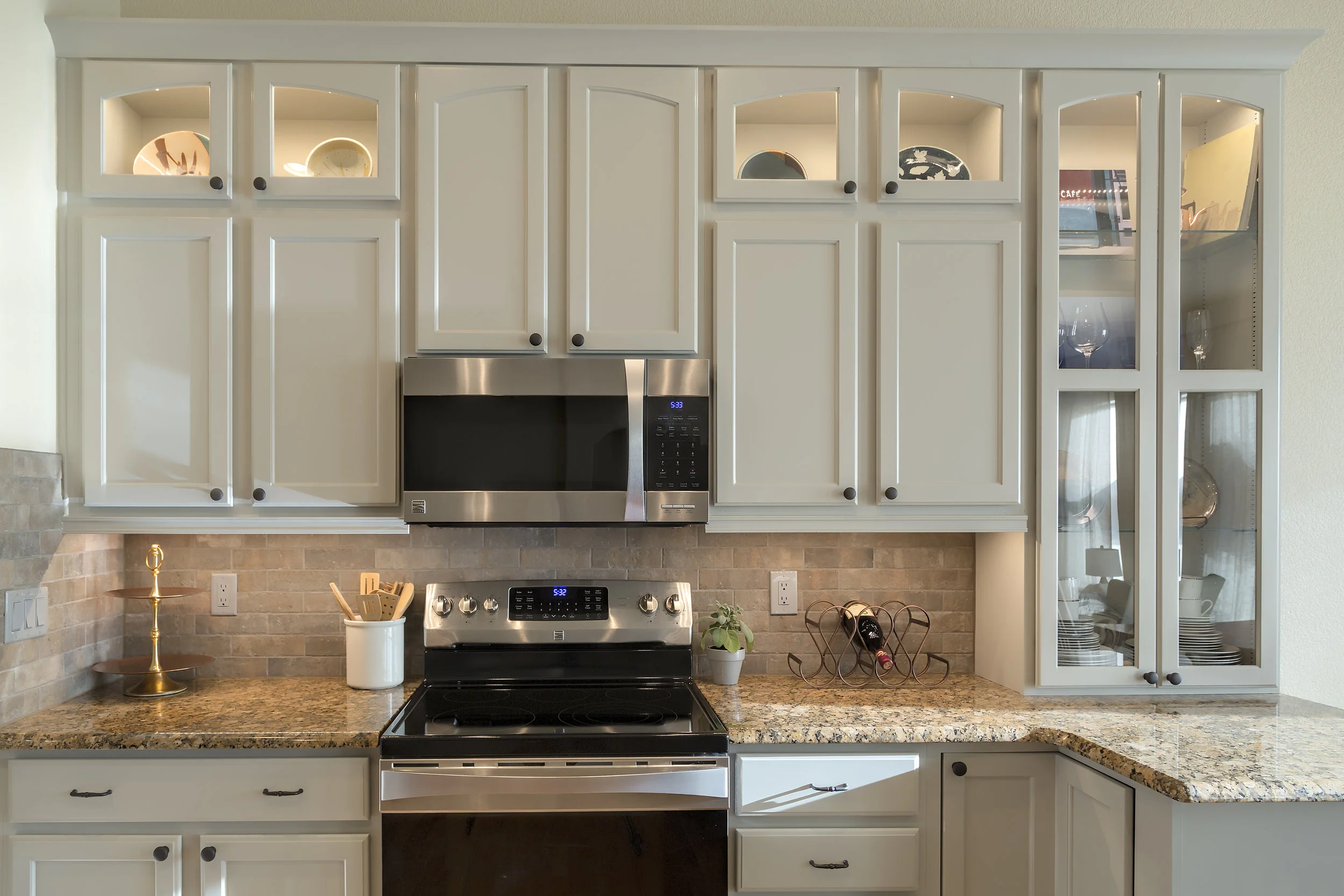 Everything about this kitchen is a "work of art," from the styling of the cabinetry to the cherished pottery and personal photography within. The "brickwork" tile blended the cabinetry to the existing granite countertops all while keeping the Colorado rustic + refinement feel. Electrical outlets are grey, receding into the background.