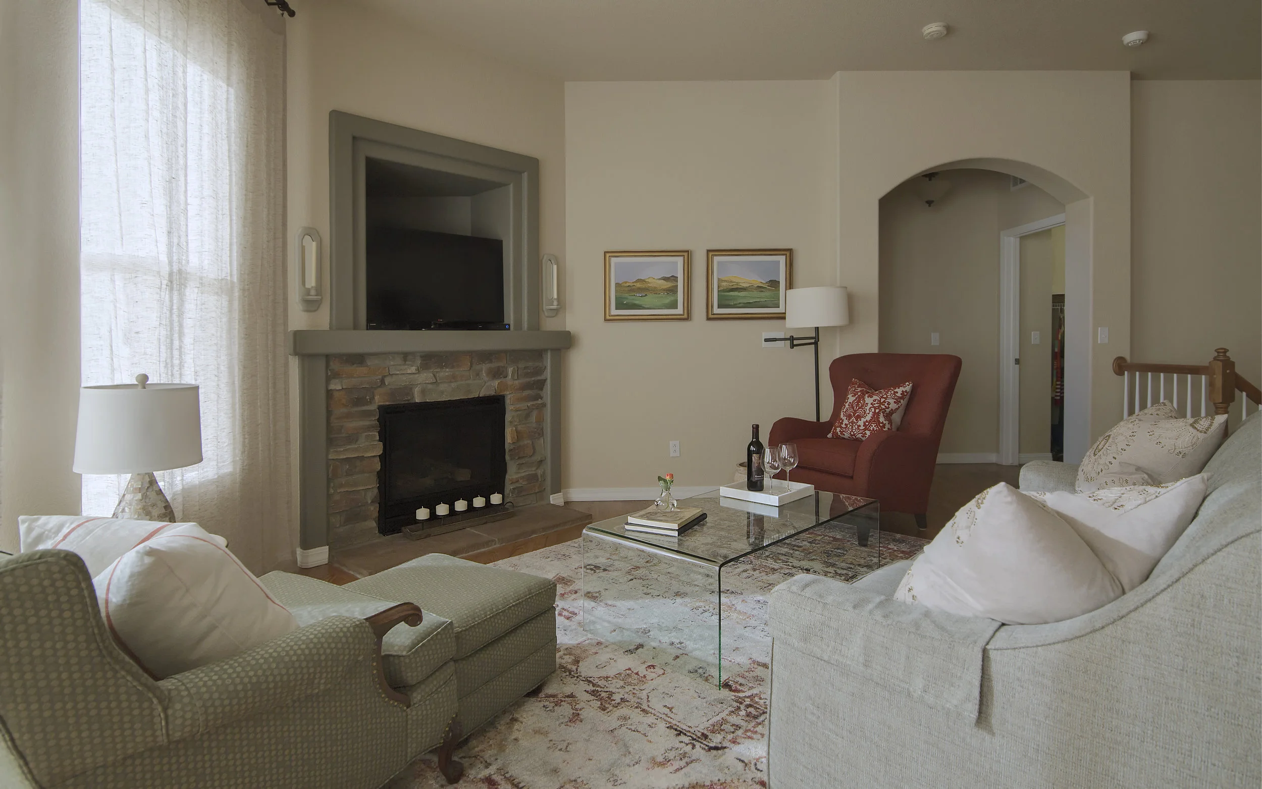 We worked all our client's furniture into the design scheme and anchored them with this lovely "vintage" rug from Loloi. The waterfall edge table was not in the original design, but we felt that it was necessary to replace our client's large, red coffee table so that the room stayed open visually. Not to mention show off that beautiful rug! Our client's late mother painted the art that is now hung to the right of the fireplace. When we first met our client, these paintings were stowed away just waiting to be hung in a place of honor. 