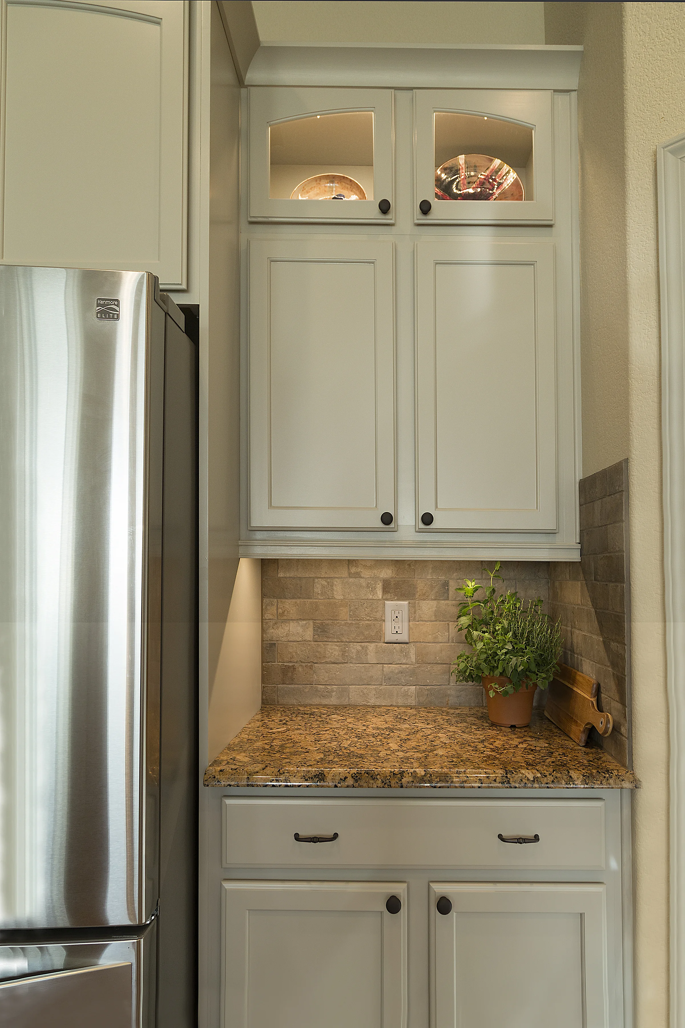 We bumped out the refrigerator cabinet to make it accessible added the refrigerator side panel for a built in look. Oil rubbed bronze hardware keeps continuity with the Colorado/Spanish feel.