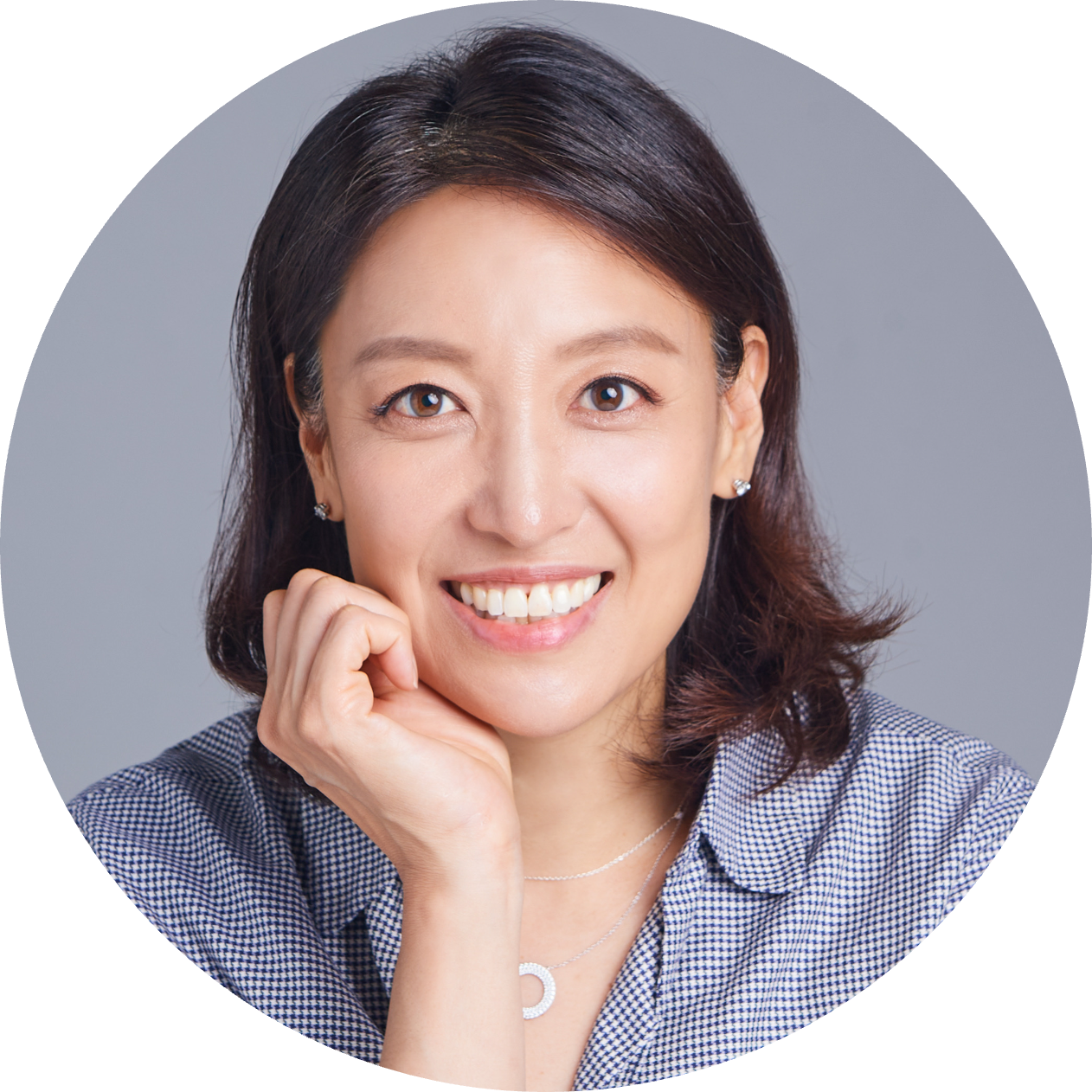 Dr. Lisa Son, with dark brown, shoulder-length hair smiles at the camera and rests her chin on her hand.