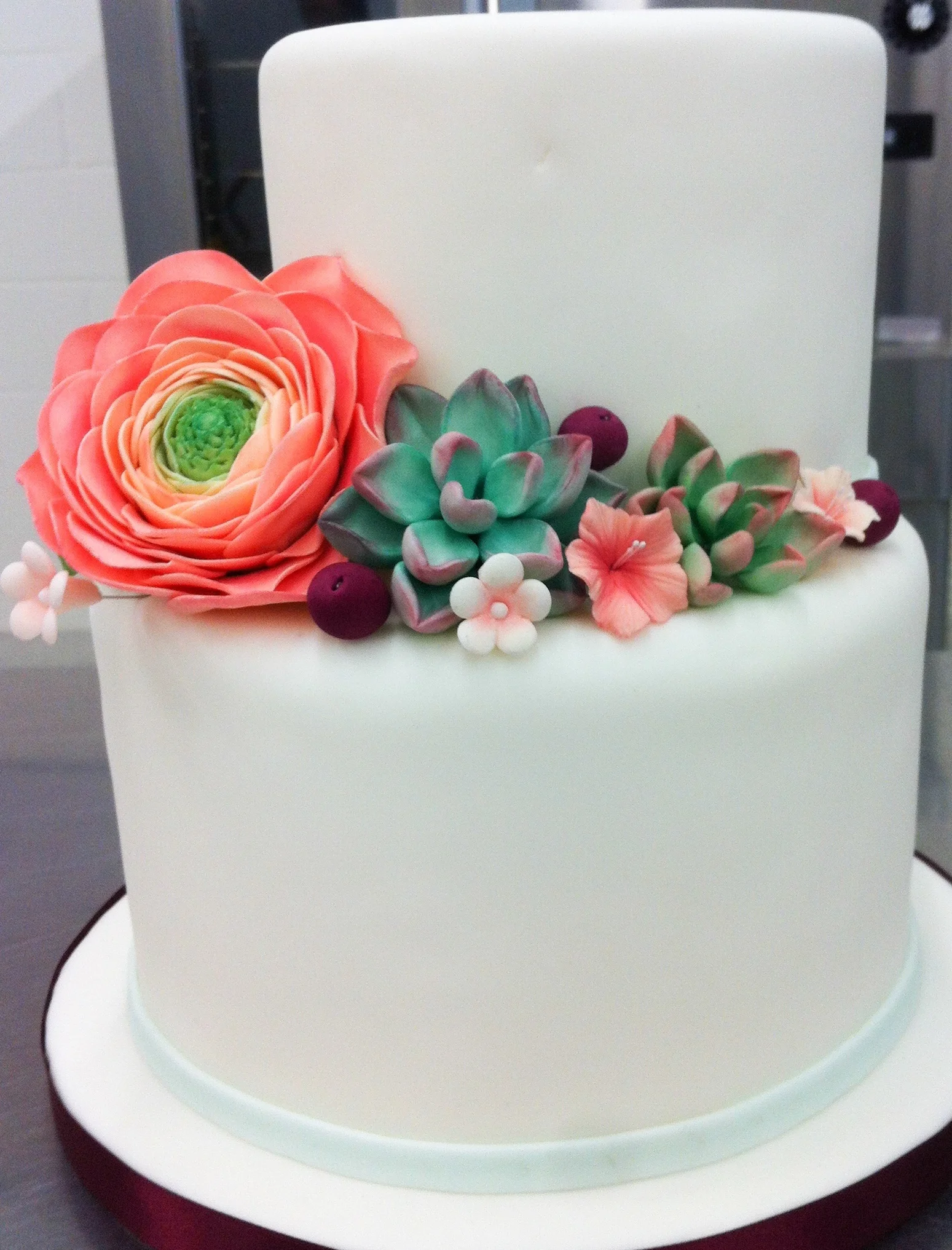 White fondant cake with handmade flowers and succulents