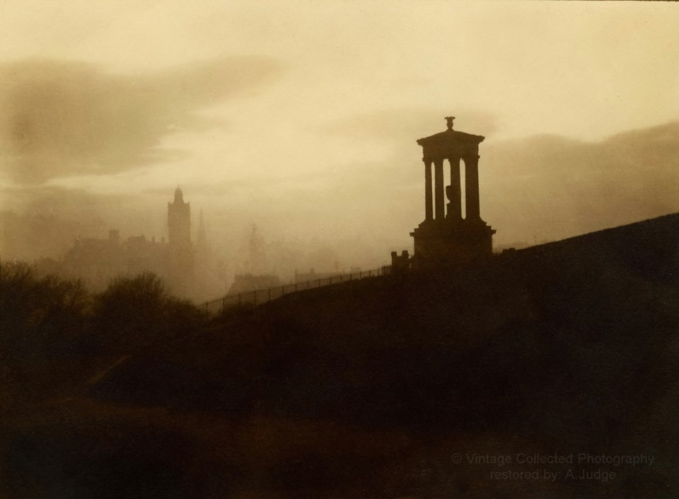 This wonderfully atmospheric photo is taken from the private collection of Alan Judge (again!). It shows Auld Reekie when it was really, ehm, reekie! Here, the photographer is standing behind the Dugald Stewart Memorial at evening time, looking along Princes Street towards the West End. The castle is only just visible on the horizon and we are also able to make out the North British Hotel and the spire of St John's Church as well as many rooves and chimney pots. The photographer is unnknown and any suggestions would be welcome. The monument itself was designed by William Henry Playfair and was built in 1831 as a memorial to the philosopher whose name it carries. He held the chair in Moral Philosophy at Edinburgh University from 1786 until his death. Those who see a resemblance between this and the nearby Burns Monument may be interested to know that they were actually both based on the Choragic Monument of Lysicrates in Athens. Both of these monuments, together with our infamous Edinburgh's Disgrace ( or National Monument ) truly are a homage to our city being the Athens of the North! With many thanks again to Alan for allowing us to use this image which highlights the beauty of our city's buildings and which we here at Scott & Brown have prided ourselves on maintaining, restoring and preserving since 1890. Please take a look at his Facebook page, https://www.facebook.com/groups/1456193791357819/?ref=nf_target&fref=nf , to enjoy more of his wonderful images from the past which he lovingly and magically restores. Photograph copyright Alan Judge, Vintage Collected Photography.