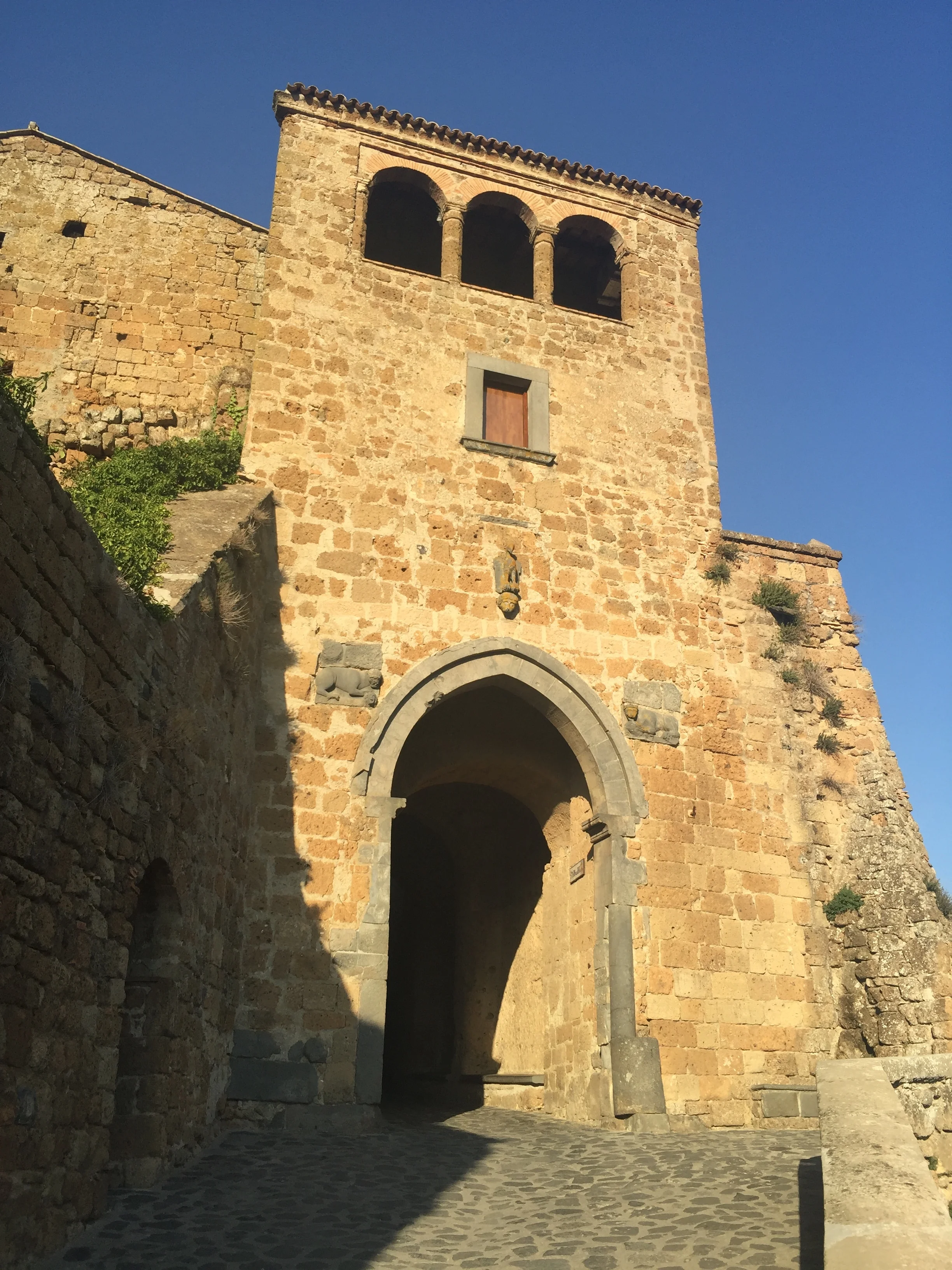 Entrance to the Civita di Bagnoregion. Cats are the first beings to welcome you here, seen wondering and enjoying the cool shades provided by the civita columns (Photo: Sumi_Sumilier)