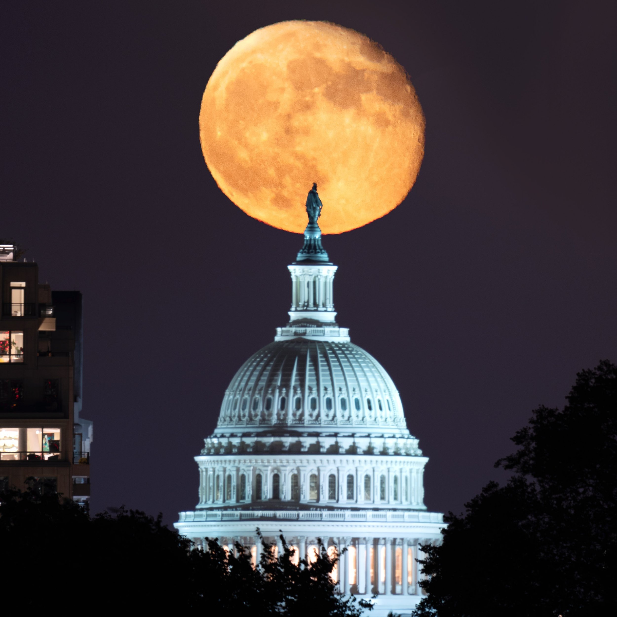 Waning Gibbous moon raises behind the Statue of Freedom atop the US Capitol building