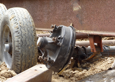 A close-up of one of the front piece carrier’s axle that bent from the strain placed upon it while being backed up the street to the construction site.