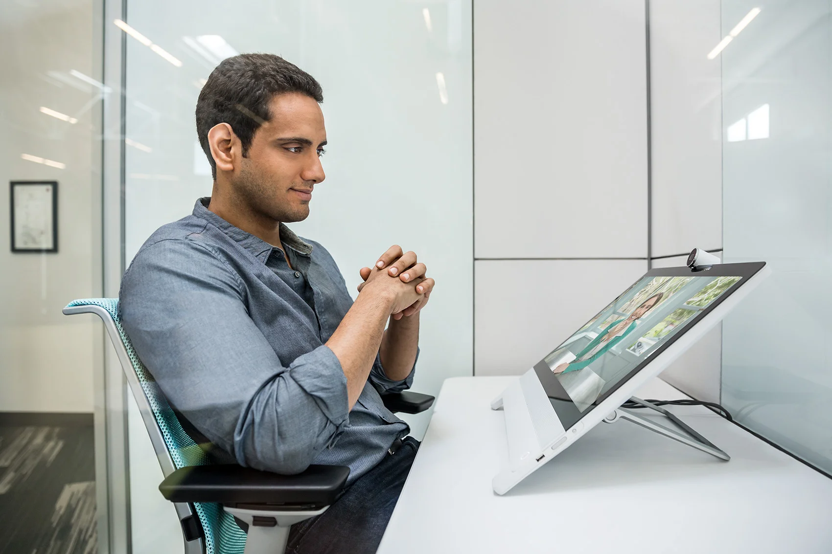 middle aged latino in natural modern office private room using desktop videoconferencing product by cisco