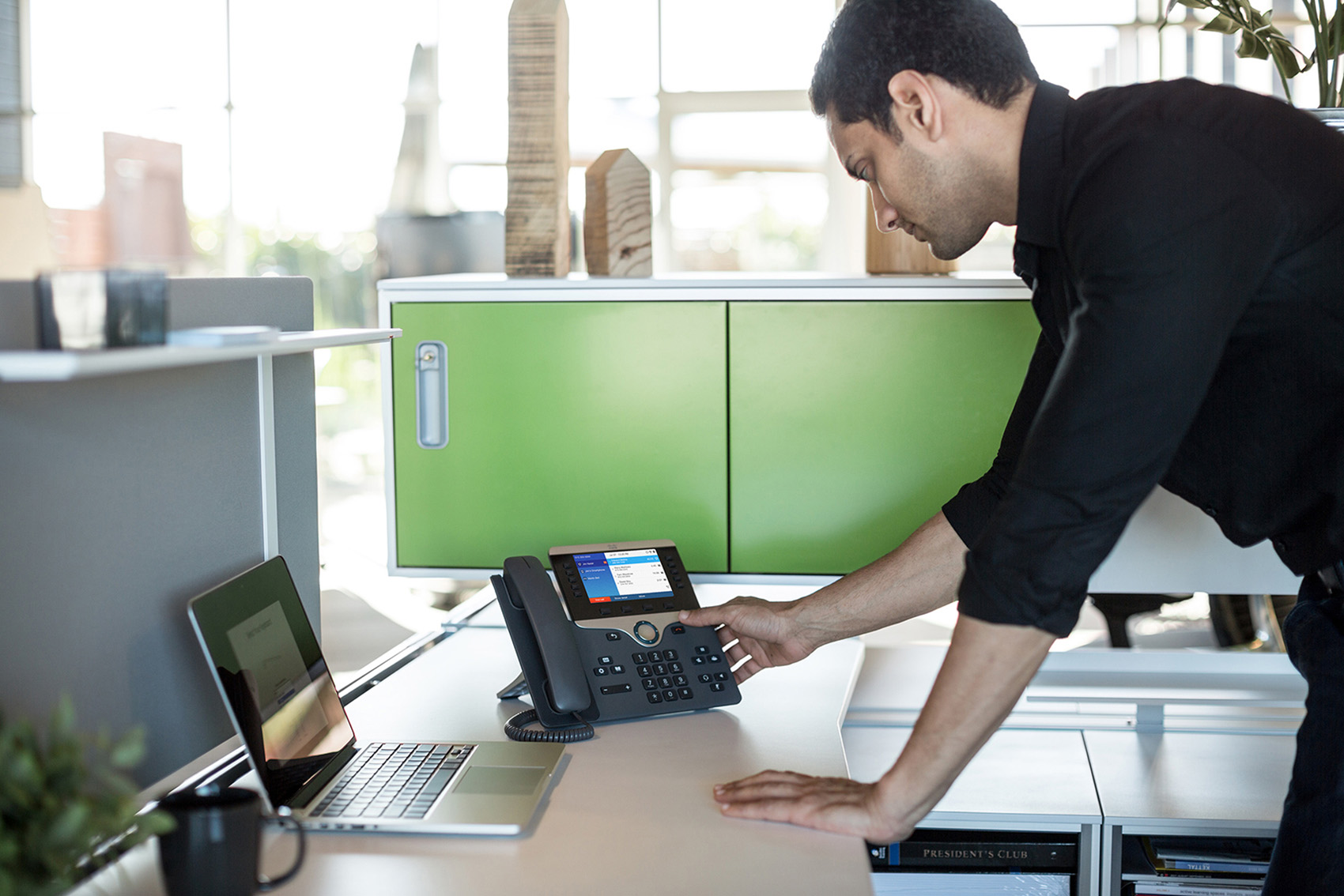 Cisco IP telephone being used by latino male in a high tech workplace