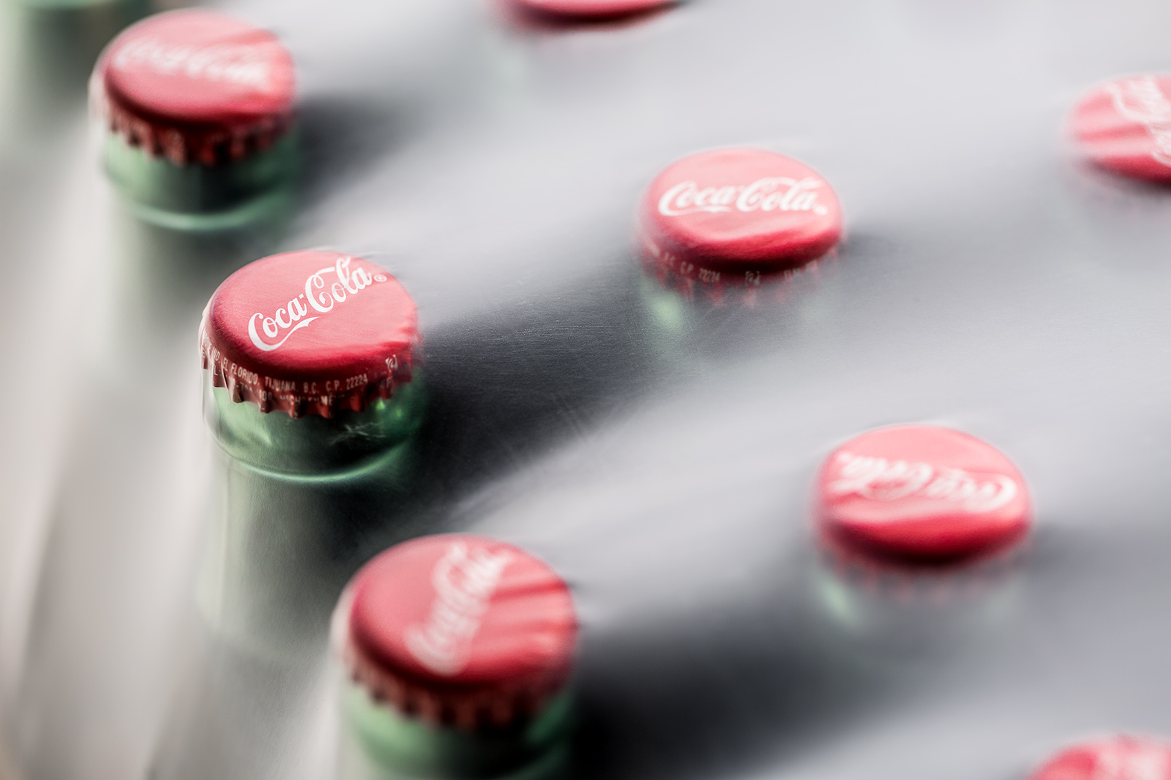 Coca Cola soda bottles close up under plastic wrap packaging