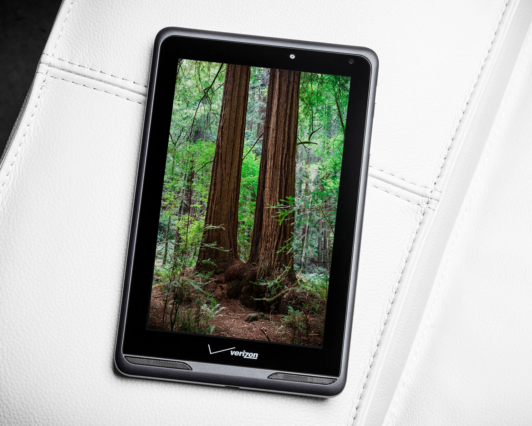 stunning product photo of Verizon lte 4g tablet with redwood forest screen on white couch