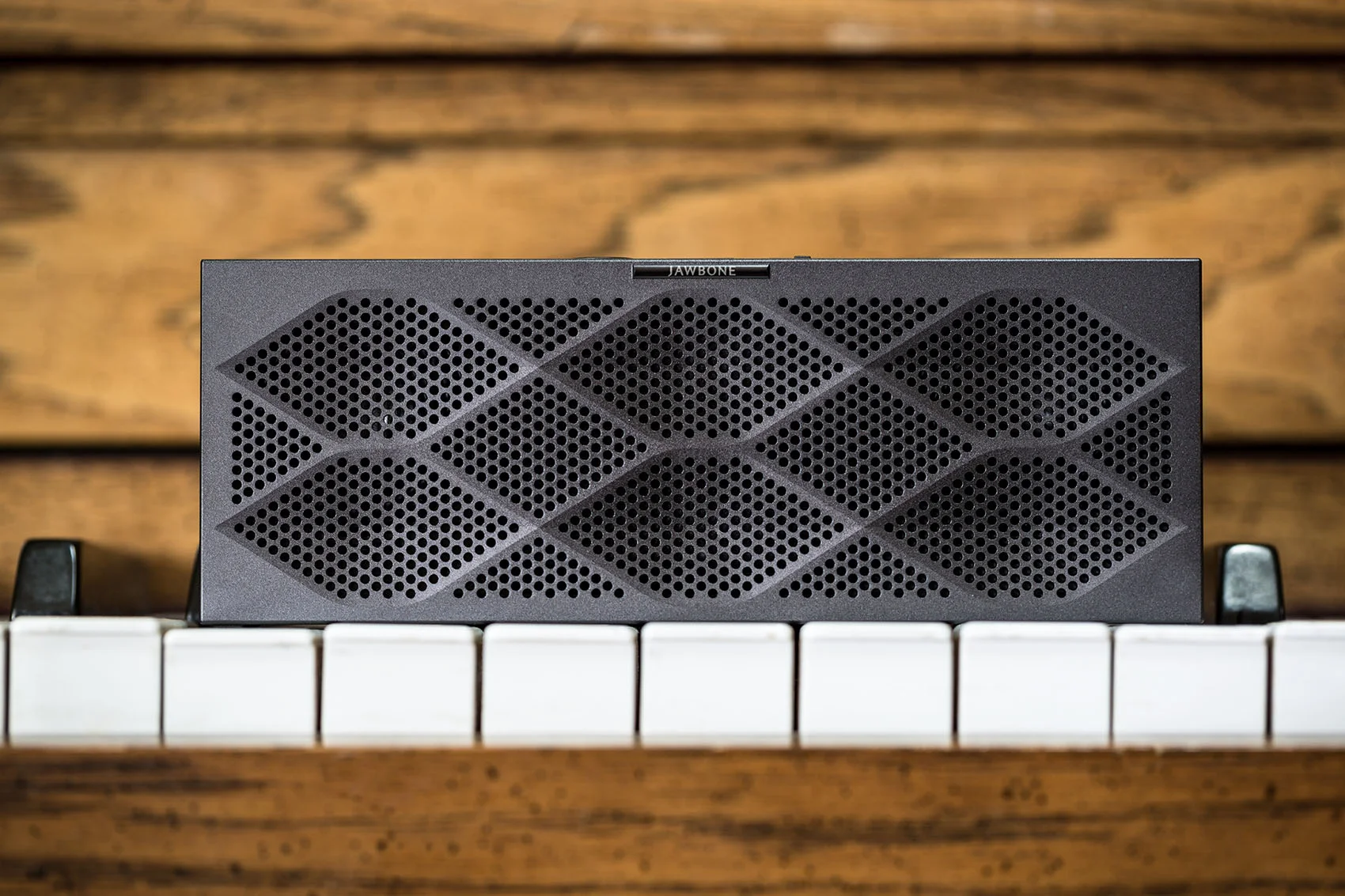 Bluetooth jawbone wireless speaker on a wood piano