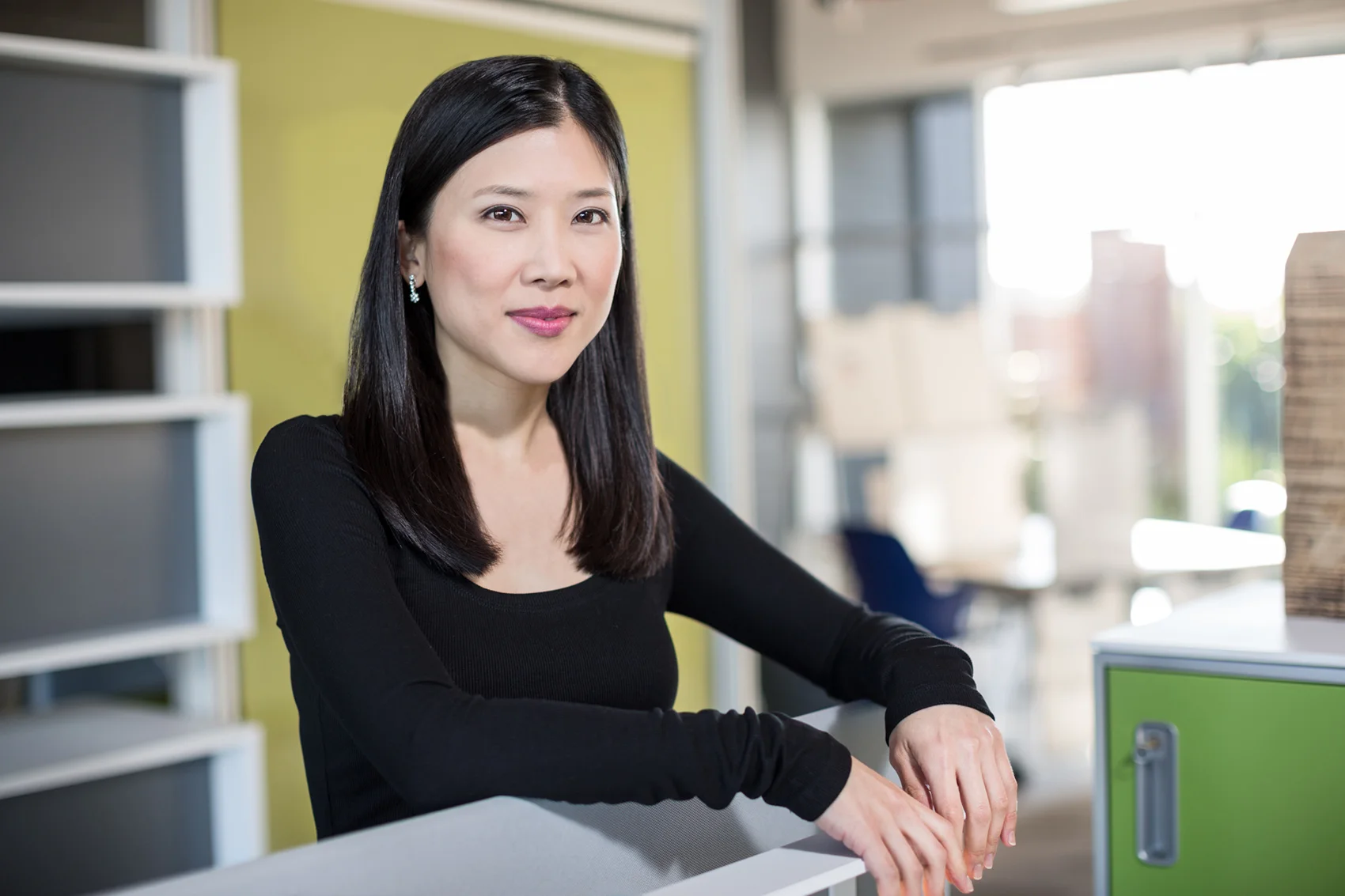 attractive Asian woman in a clean modern office with soft daylight background