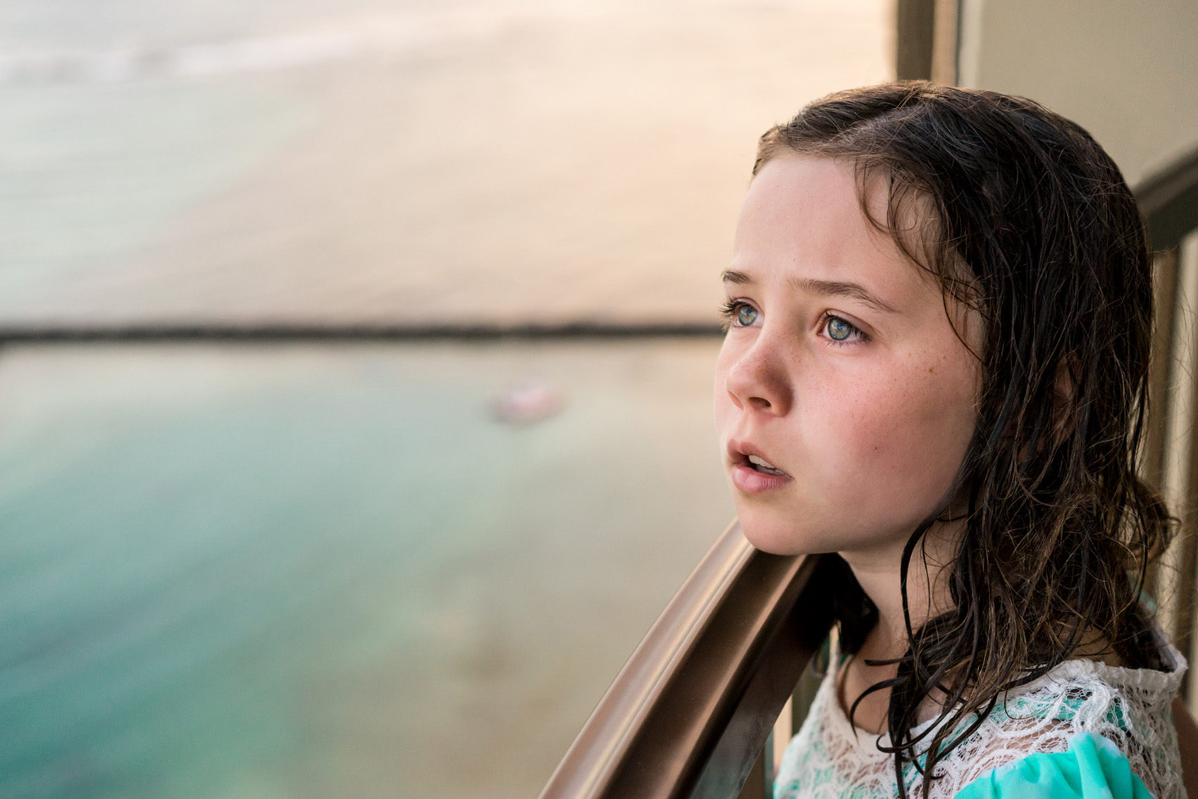 Young elementary school girl looking out over the beach in Hawaii