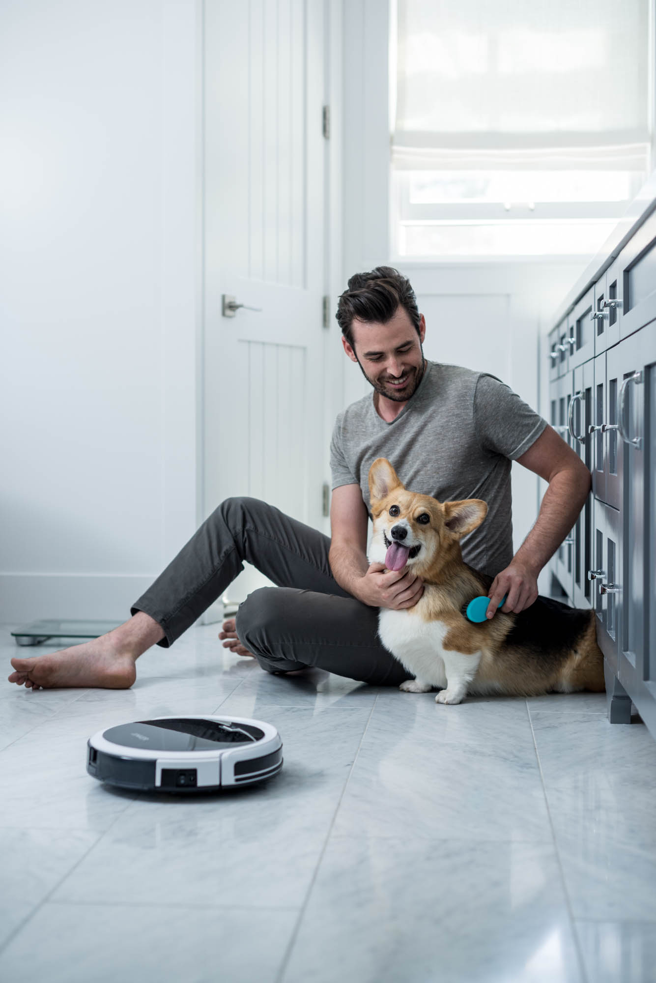 Man with Corgi dog and vacuum