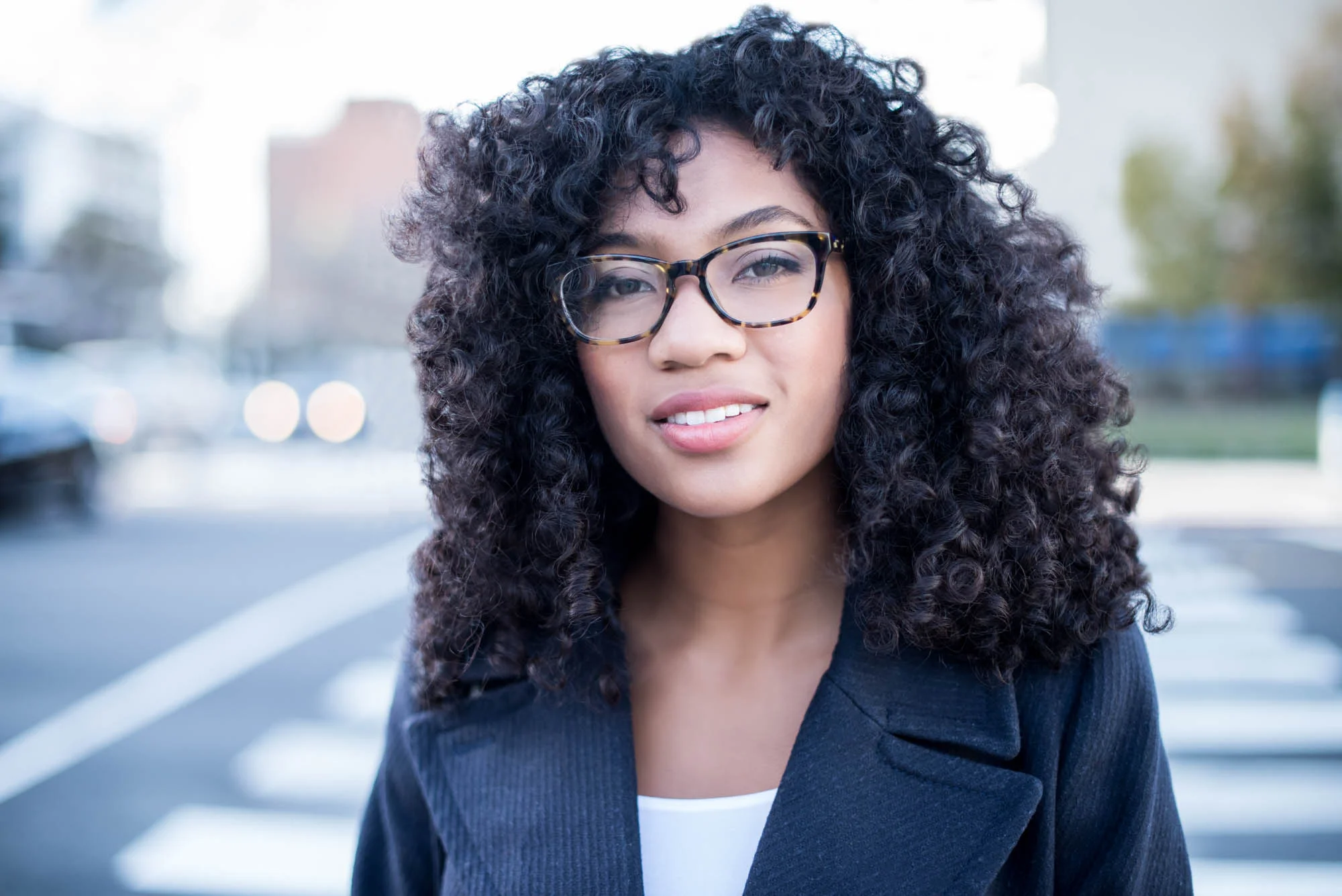 Young african american woman in glasses in a city