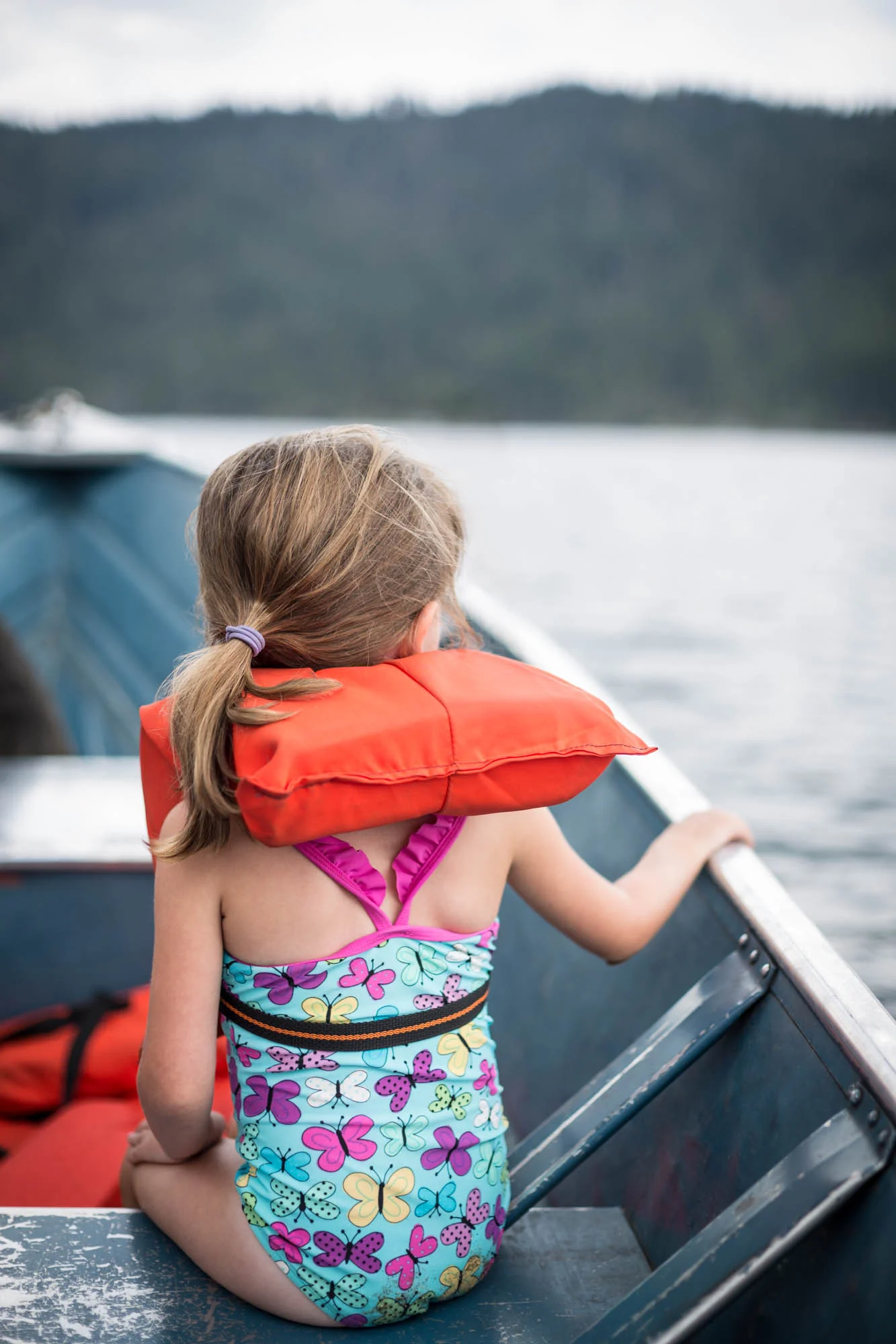 Young girl wearing a life vest on a small boat