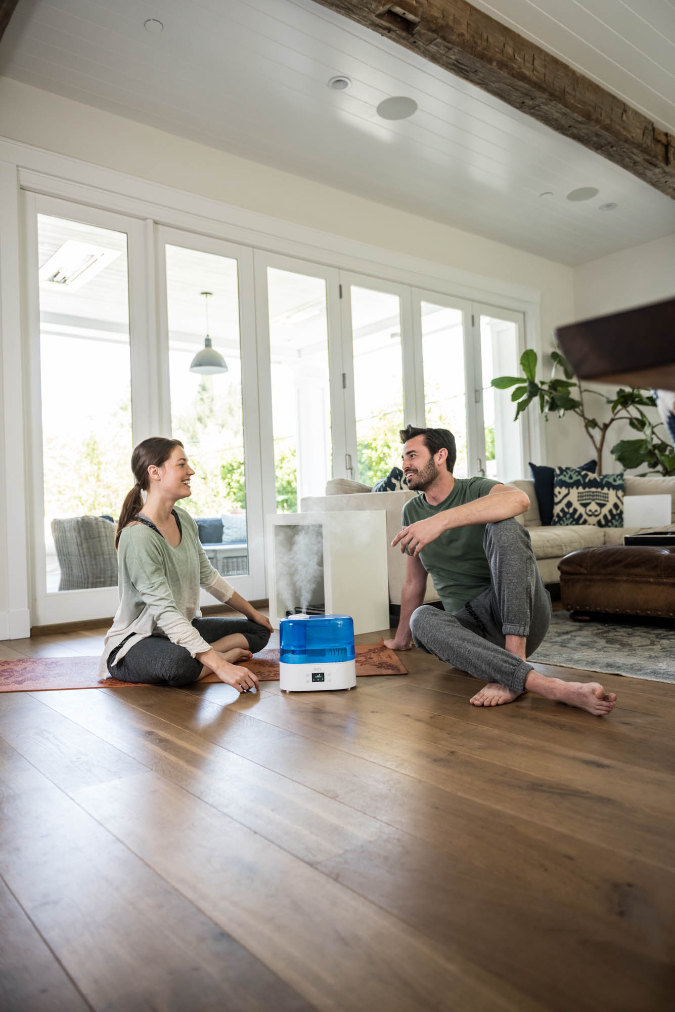 Young couple talking on the floor with a humidifier