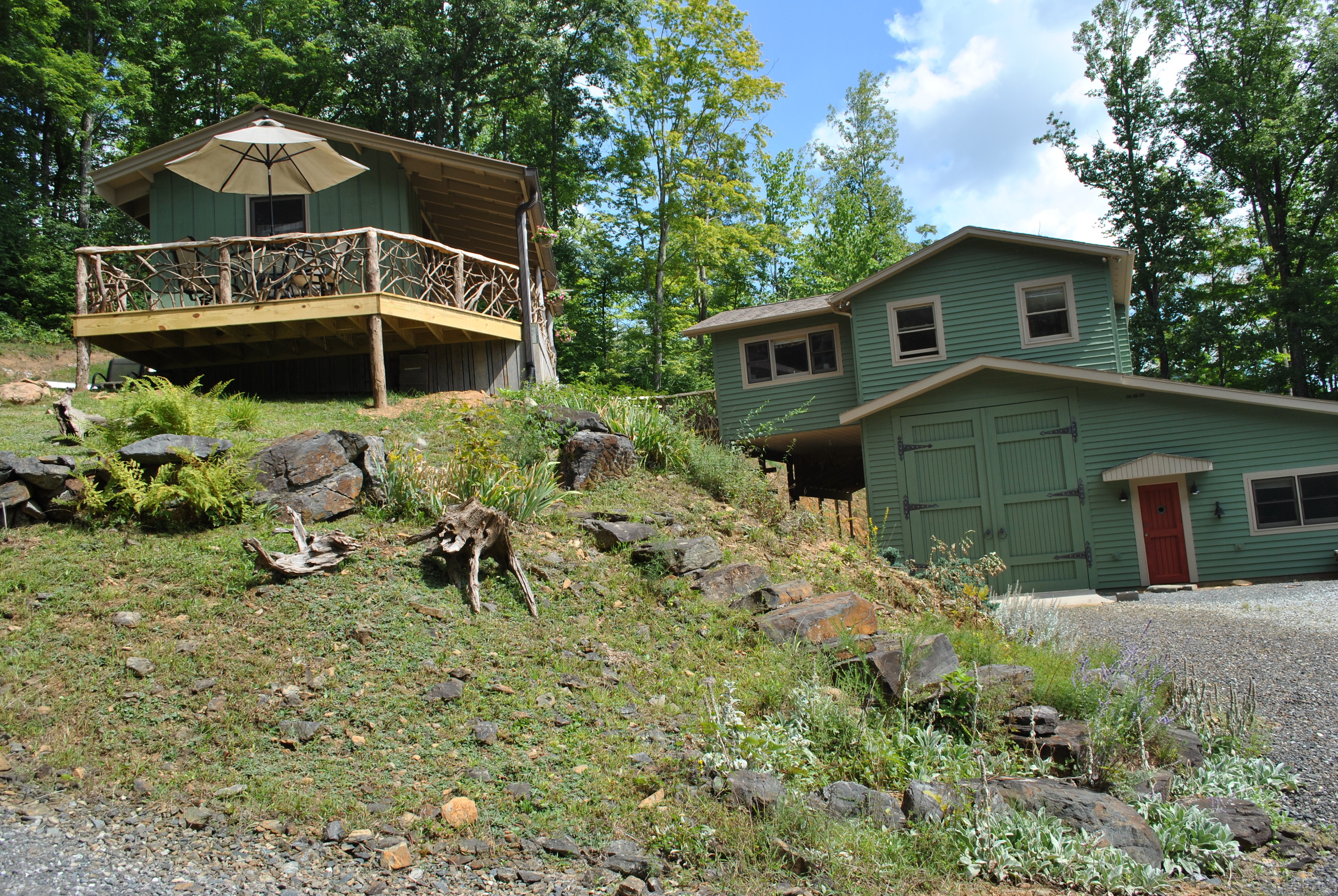 View of cabin and main house from side driveway