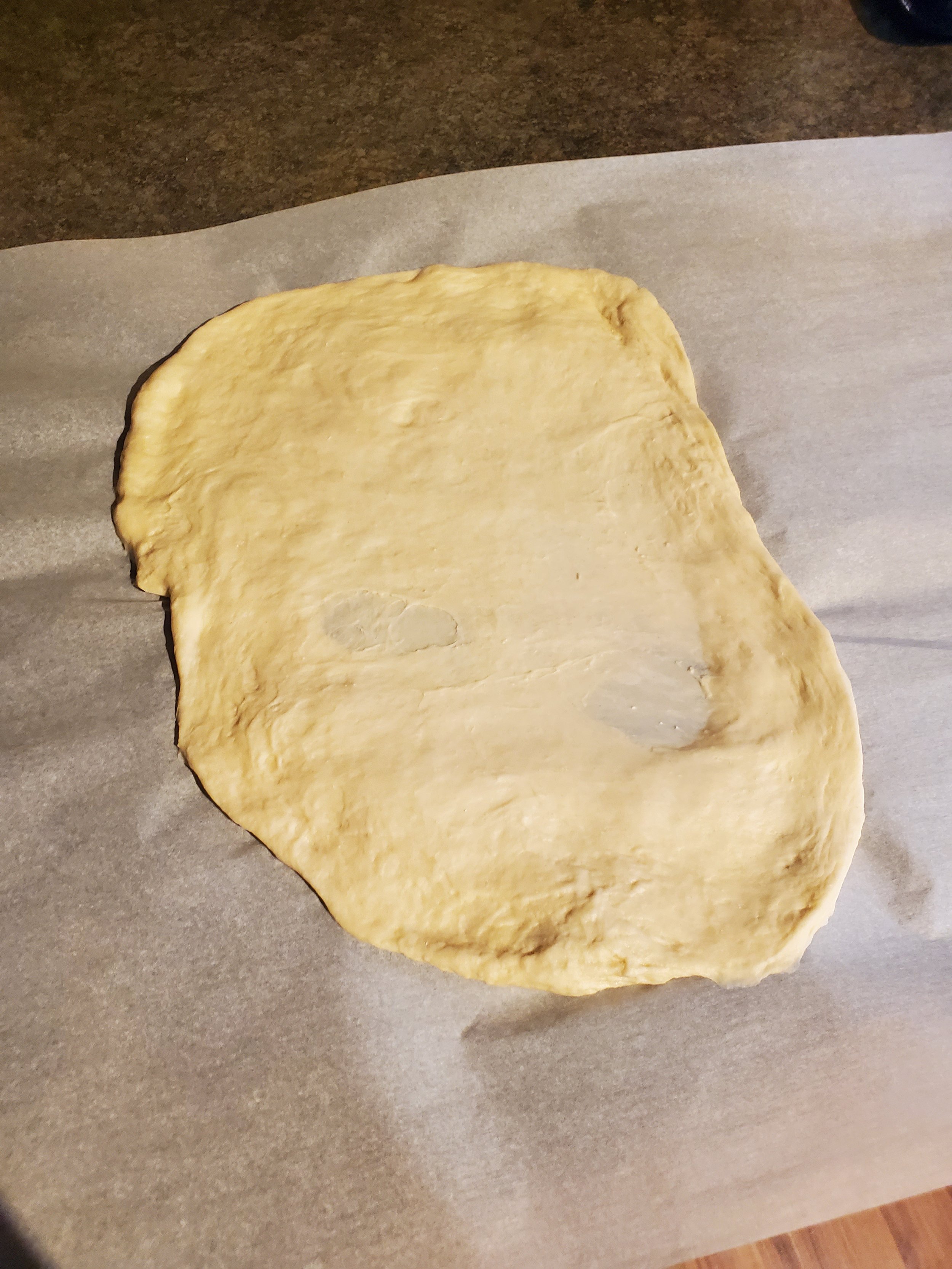 Rolling out your dough and stretching it to get ready for the stromboli