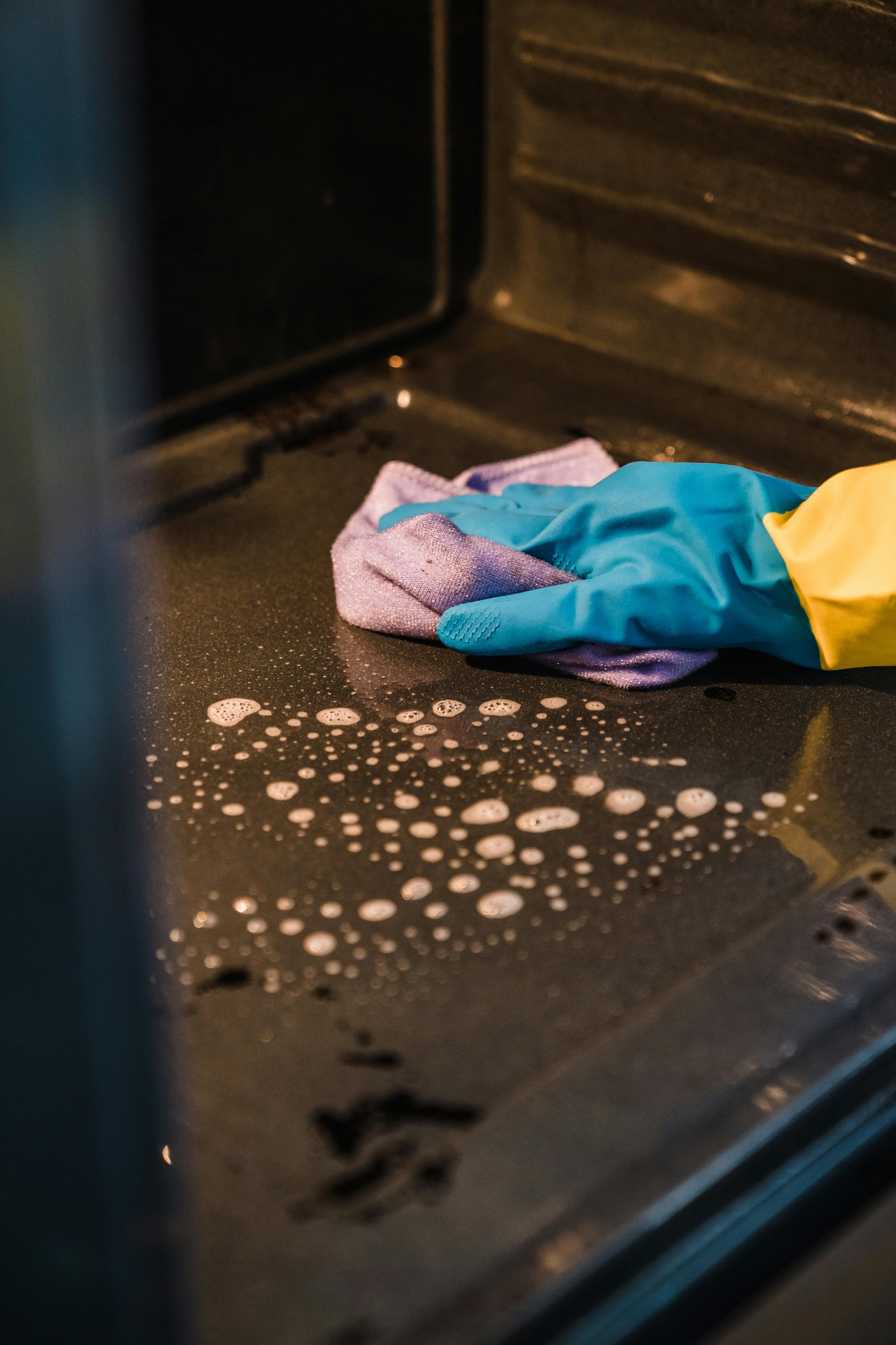 Homeowner wiping residue from an oven after a self-clean cycle