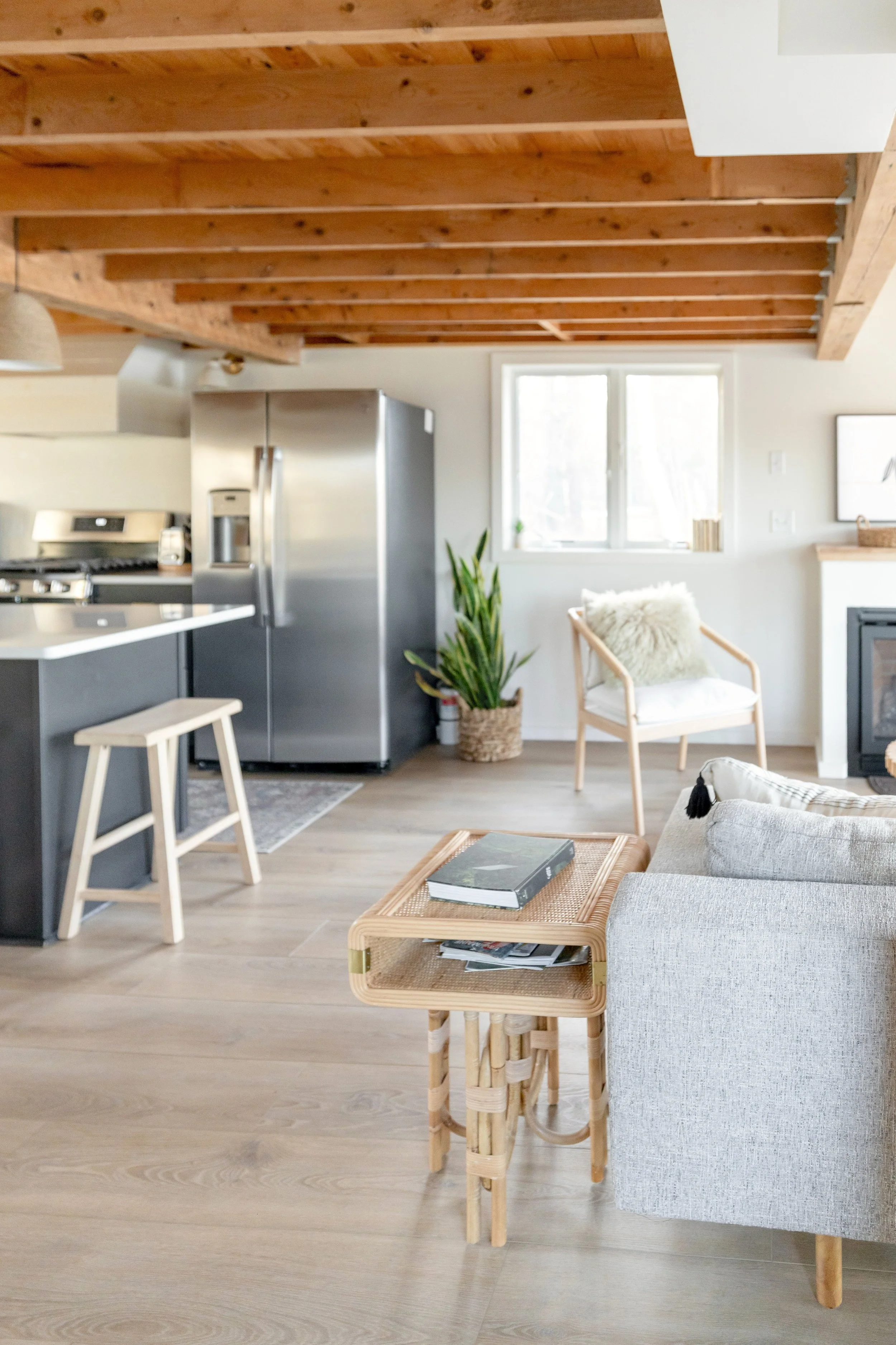 Bright modern living room featuring hardwood floors and decorative ceiling beams