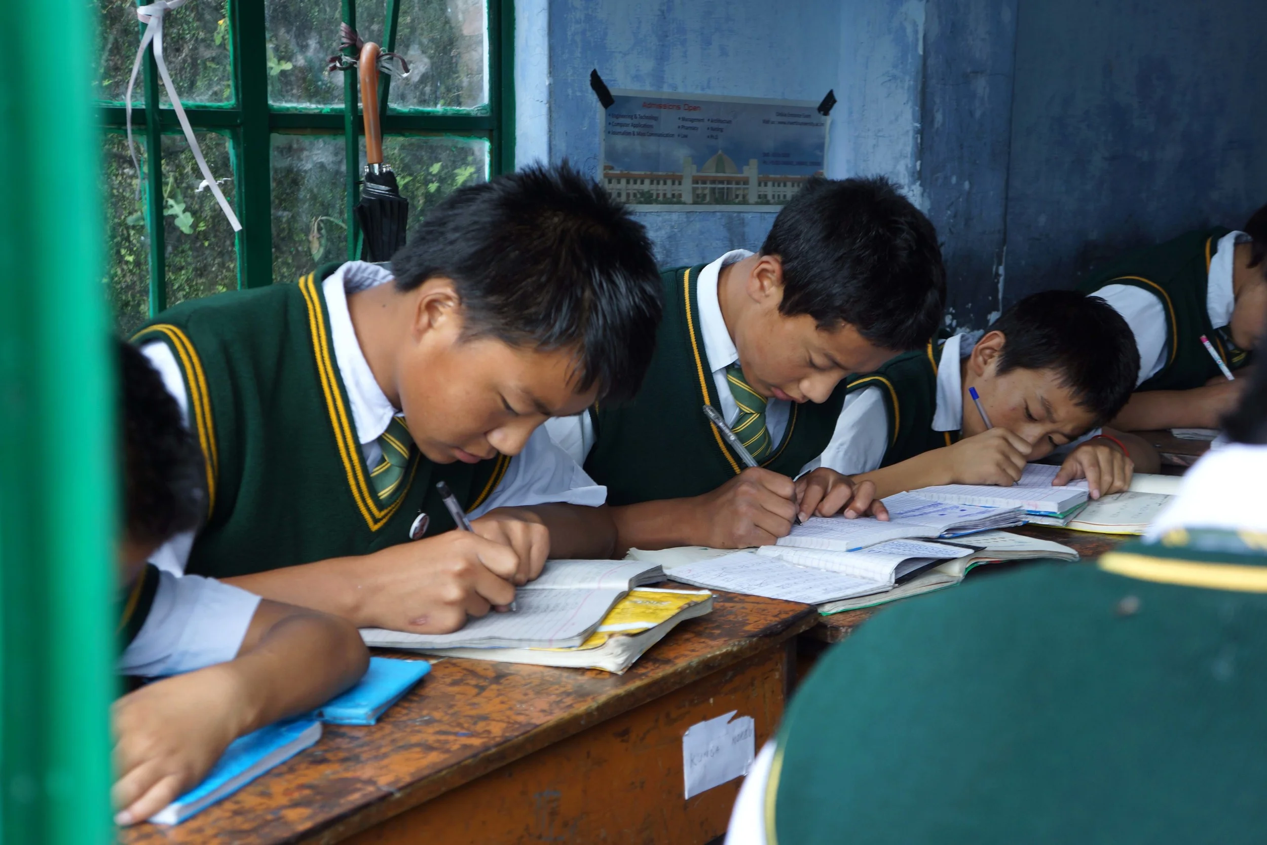 Tibetan schoolboys working with their heads down