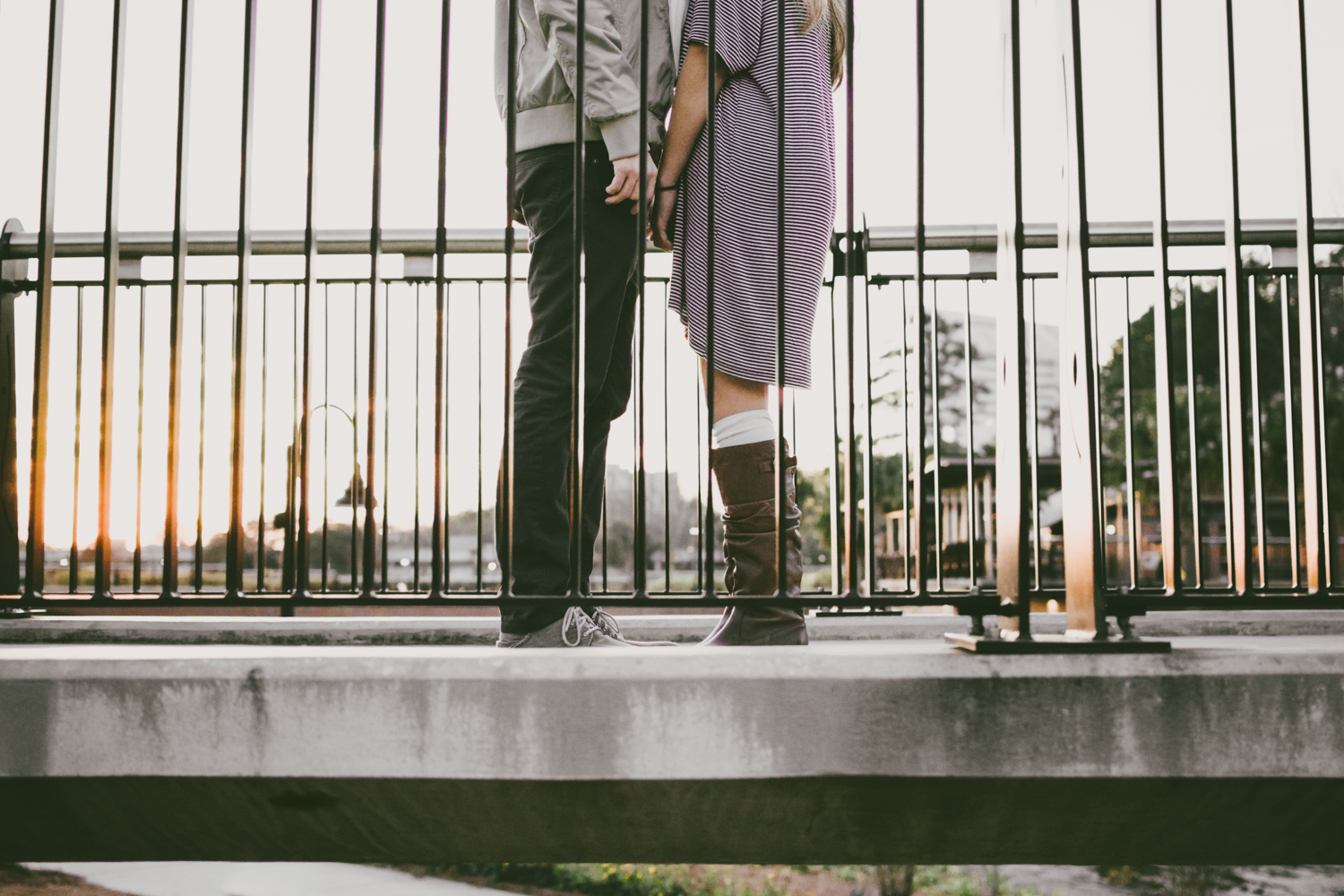 Jake and Erica standing on a bridge with the sun behind them